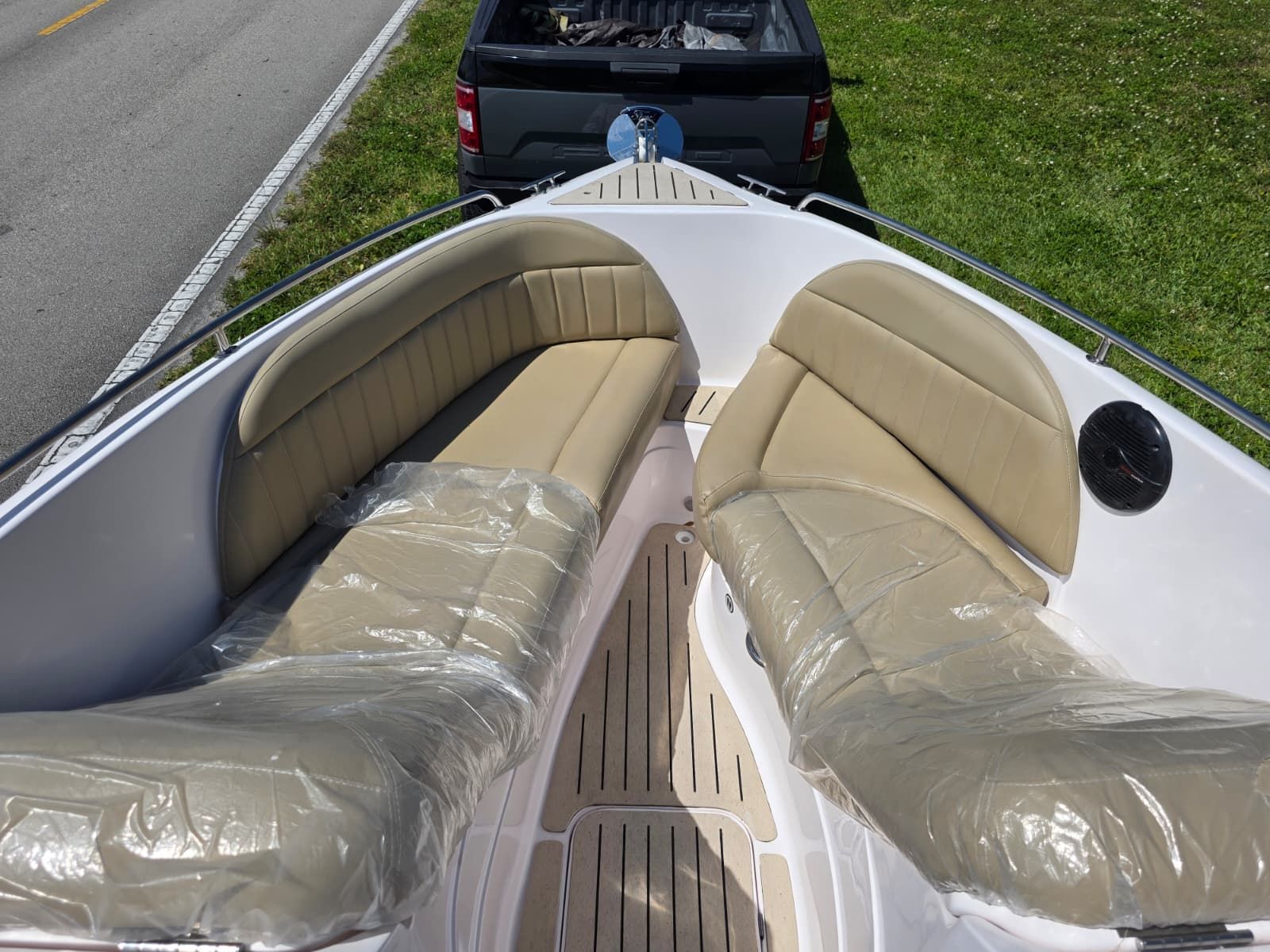 The image shows the bow area of a Coral 26 boat with beige seating.