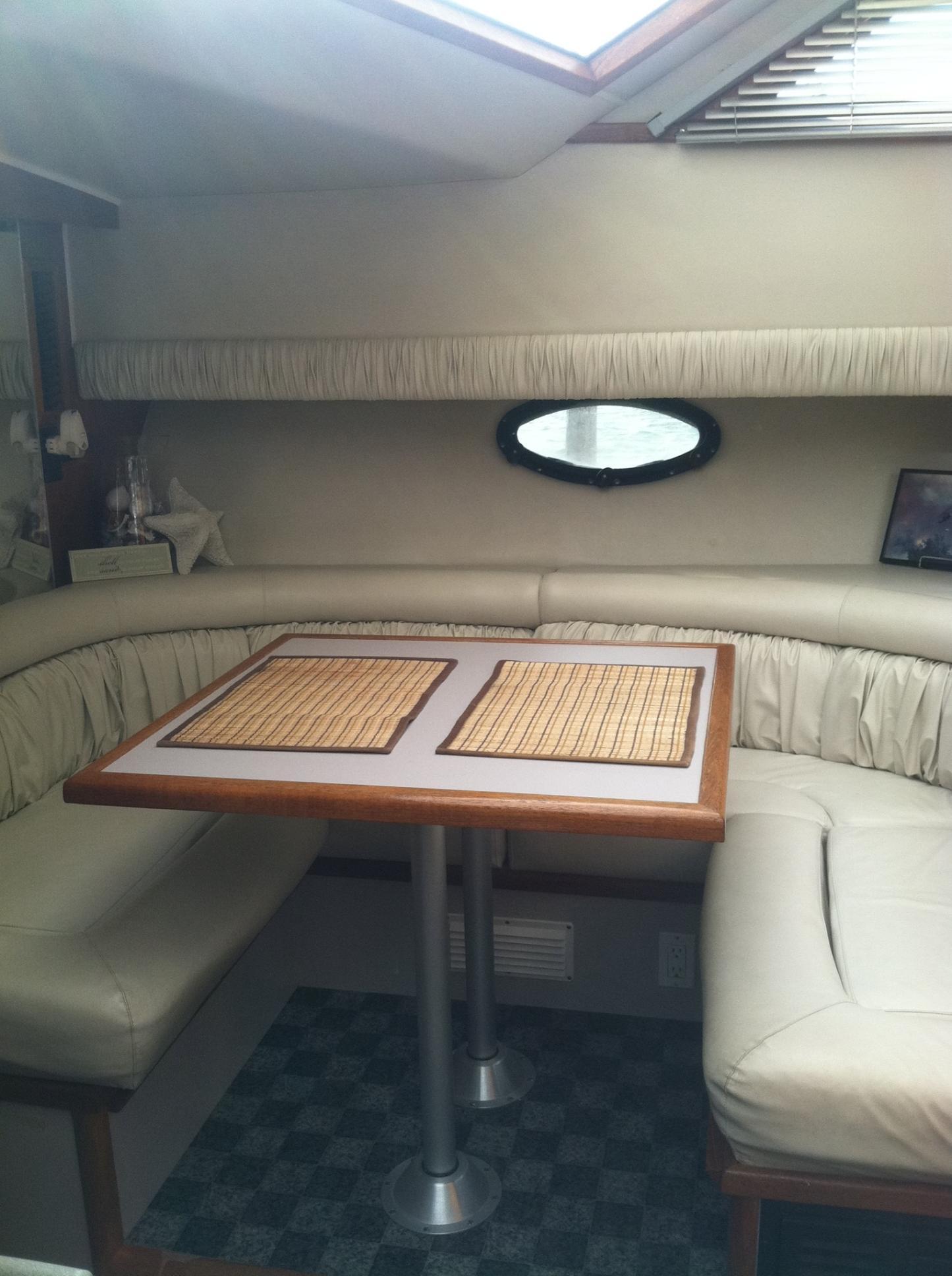 1989 Californian 48 Motor Yacht interior with cozy dining area and cushioned seating.
