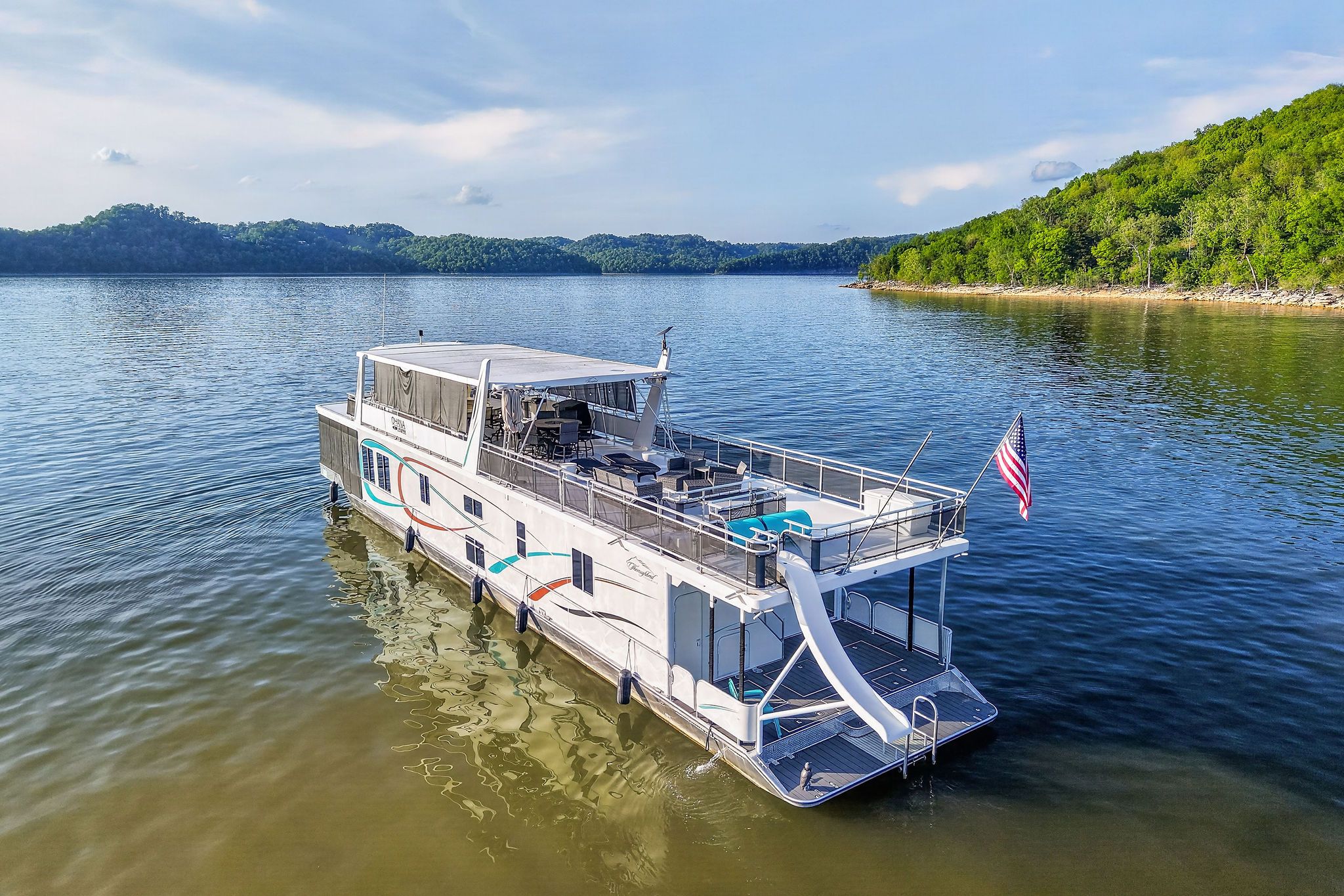 Houseboat on lake with slide and American flag, 2010 model.