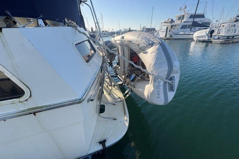 1987 Tollycraft 34 Sundeck Motor Yacht with dinghy, docked in a marina.