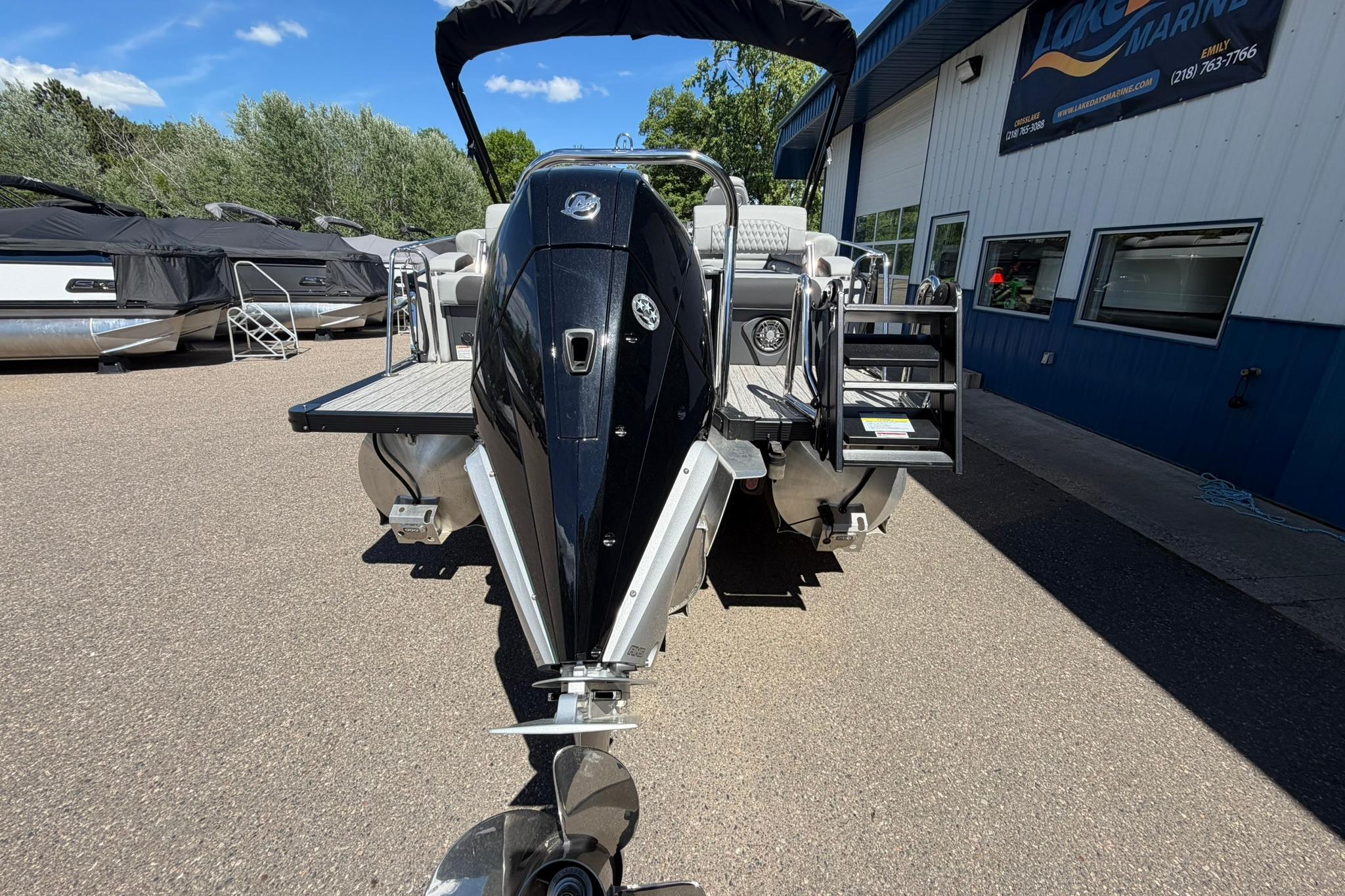 2026 Avalon Catalina Quad Lounge Shift boat at marina, rear view with motor.