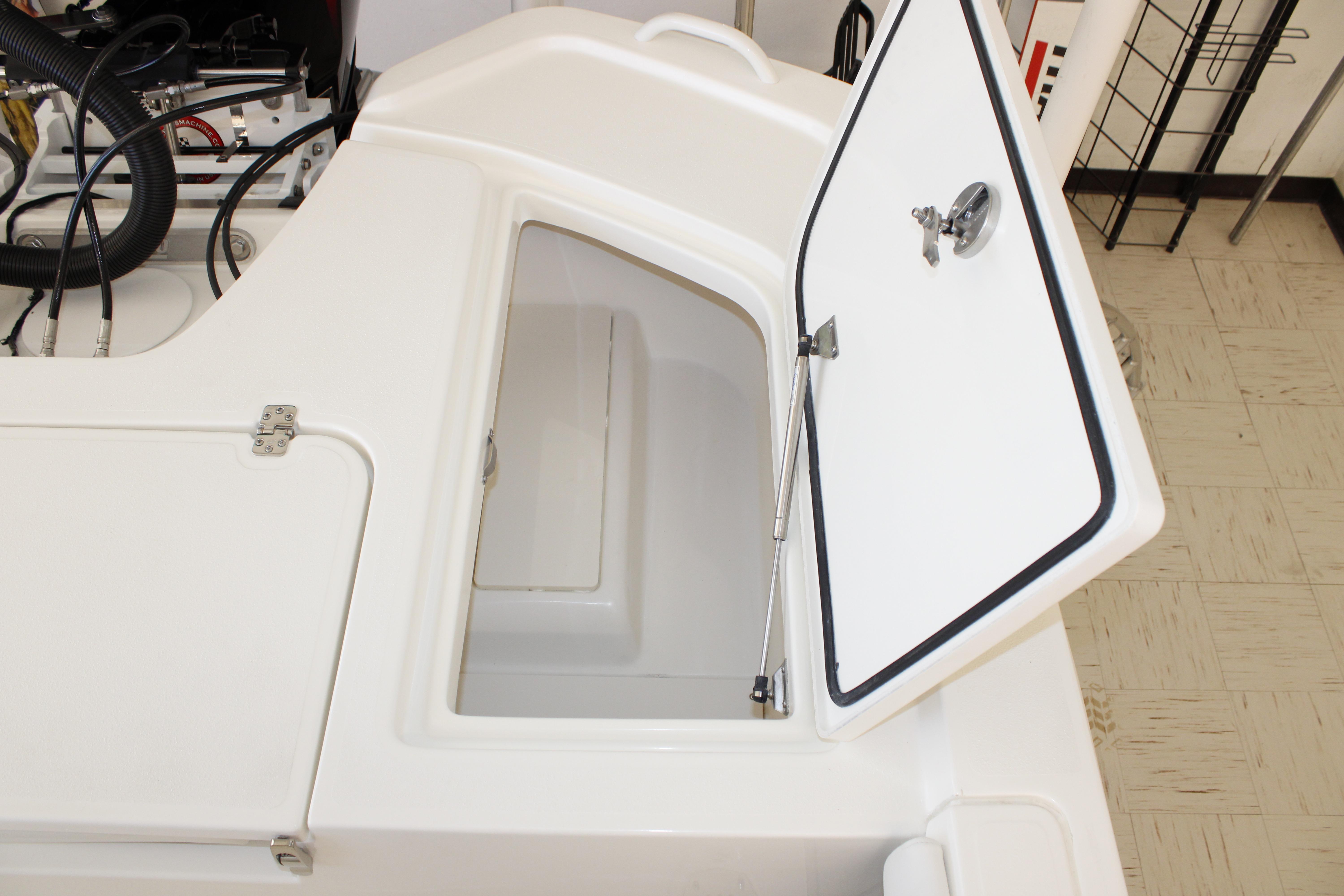 Open storage compartment on a 2026 Mako 24 APEX boat, showcasing interior space.
