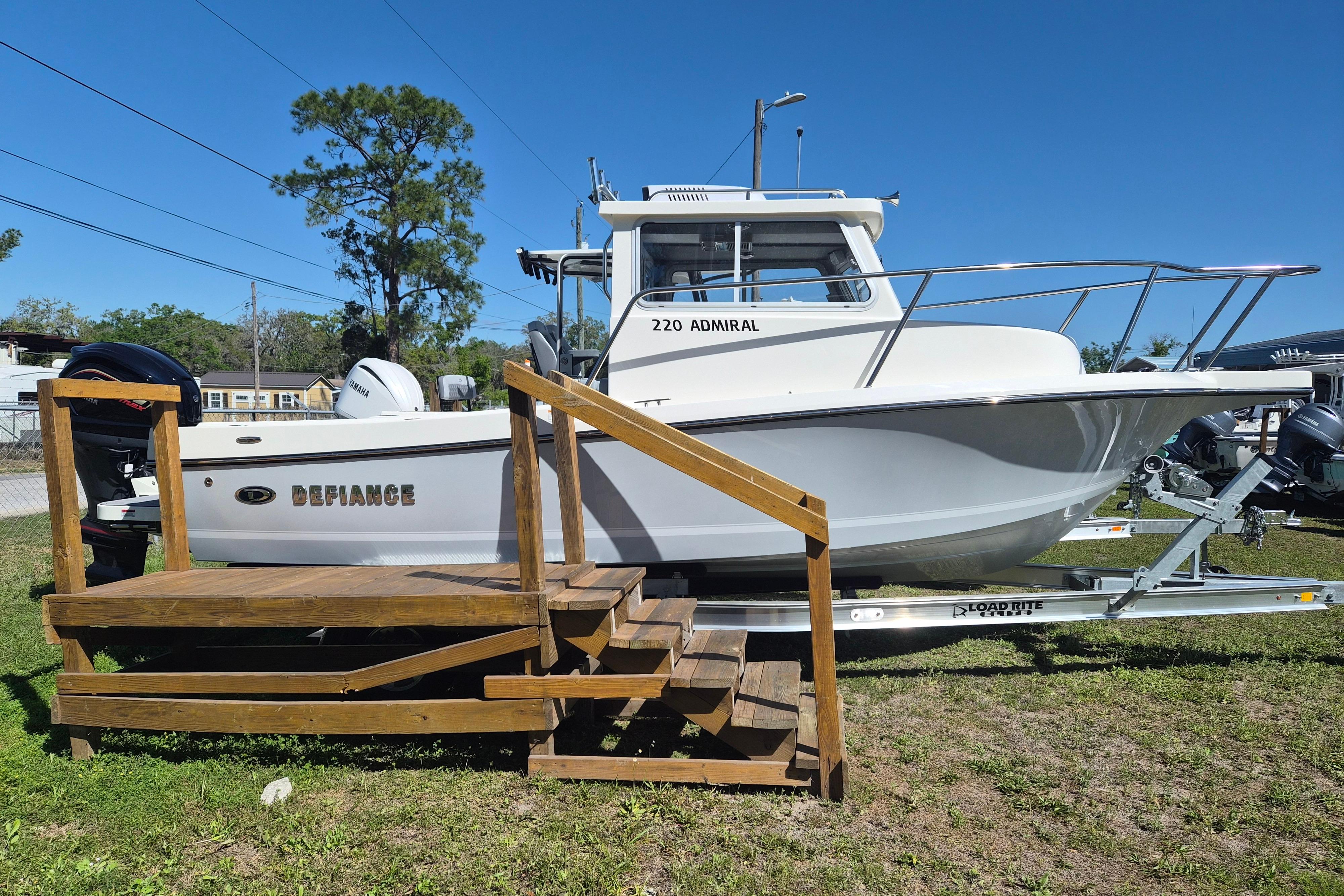 2026 Defiance Admiral 220 EX boat on trailer, displayed outdoors under clear blue sky.