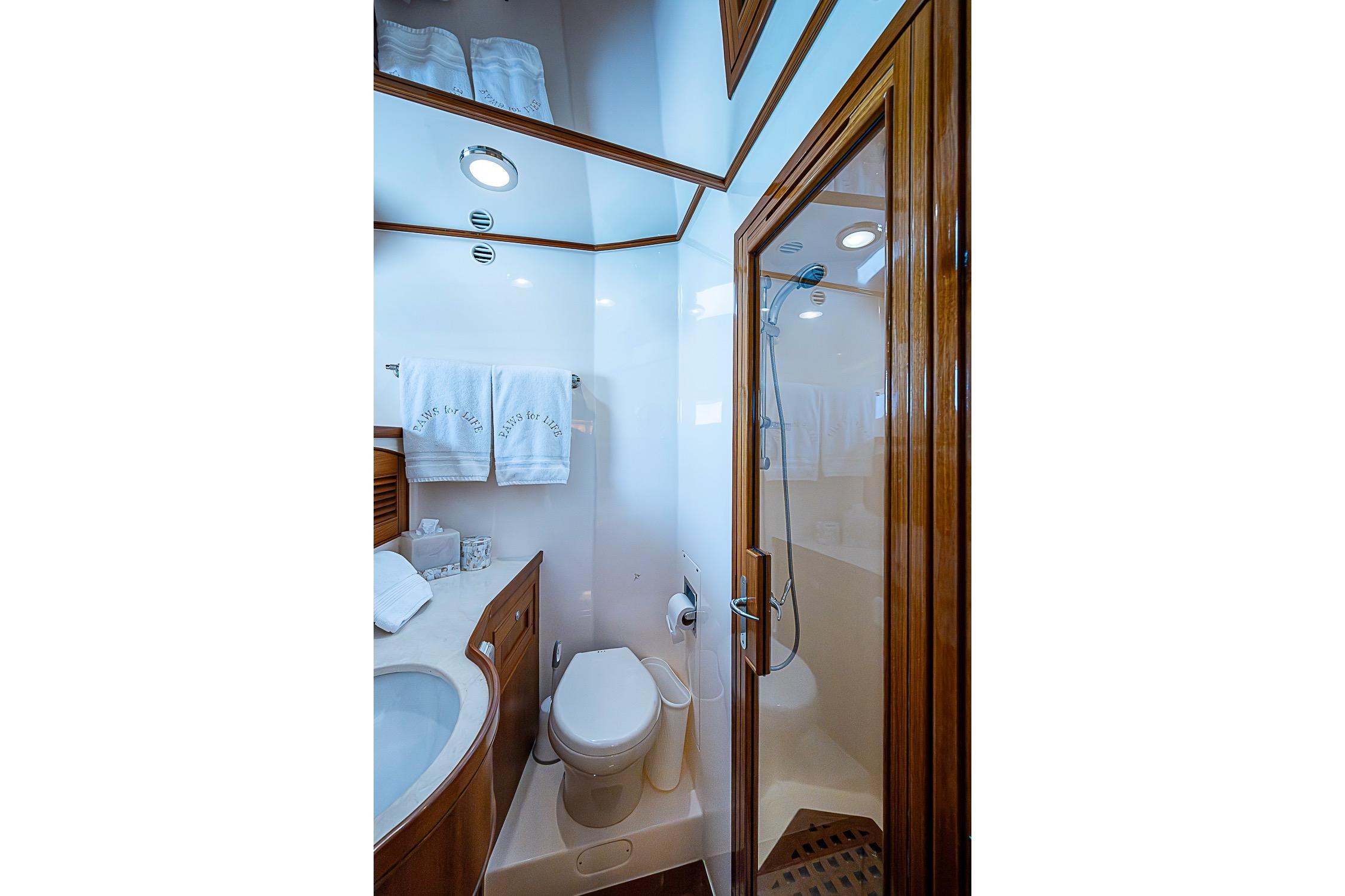 Luxurious bathroom in 2014 Marlow 80 Explorer yacht with shower and elegant wood finishes.