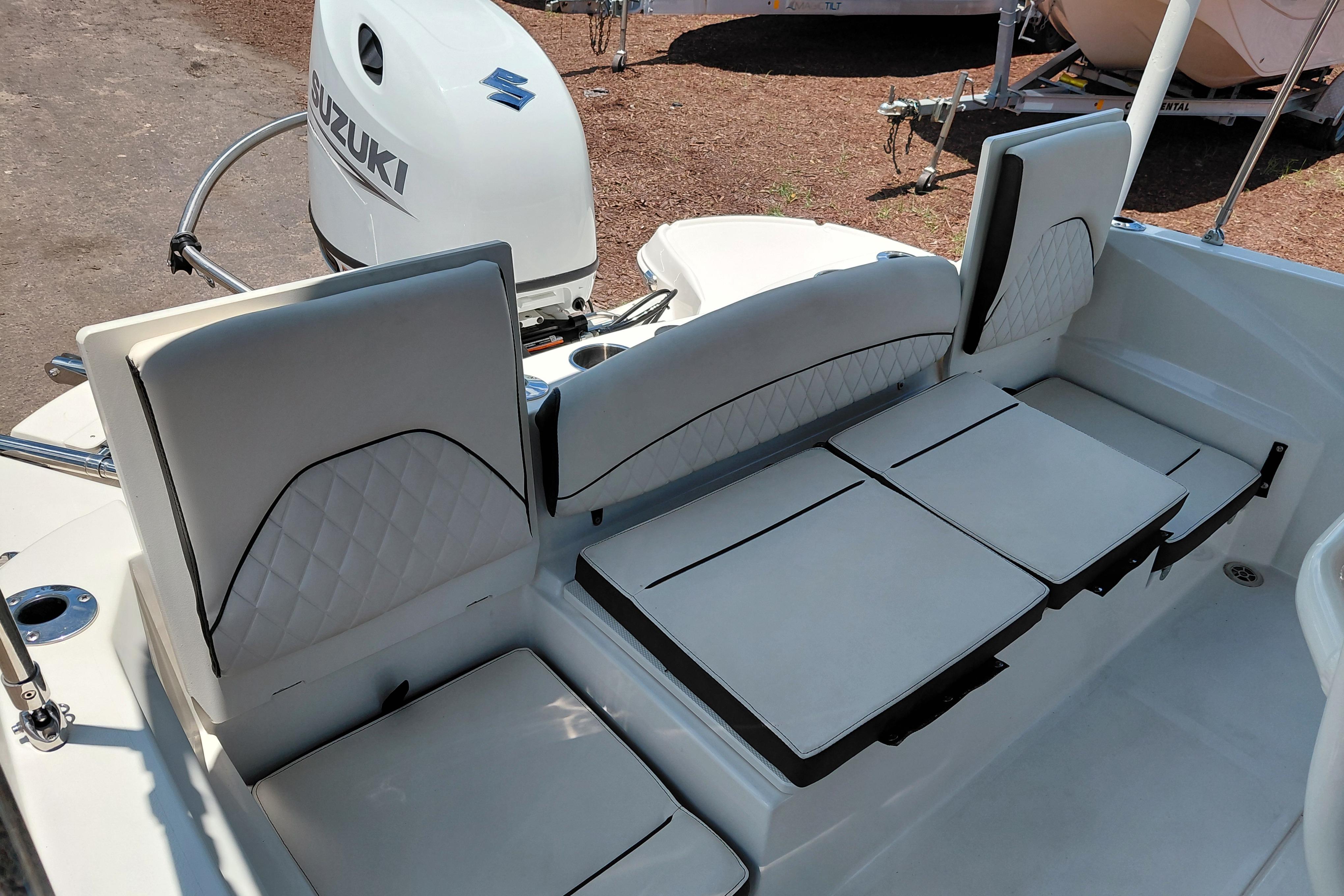 2023 Stingray 206 CC boat interior with Suzuki outboard motor, featuring white cushioned seating.