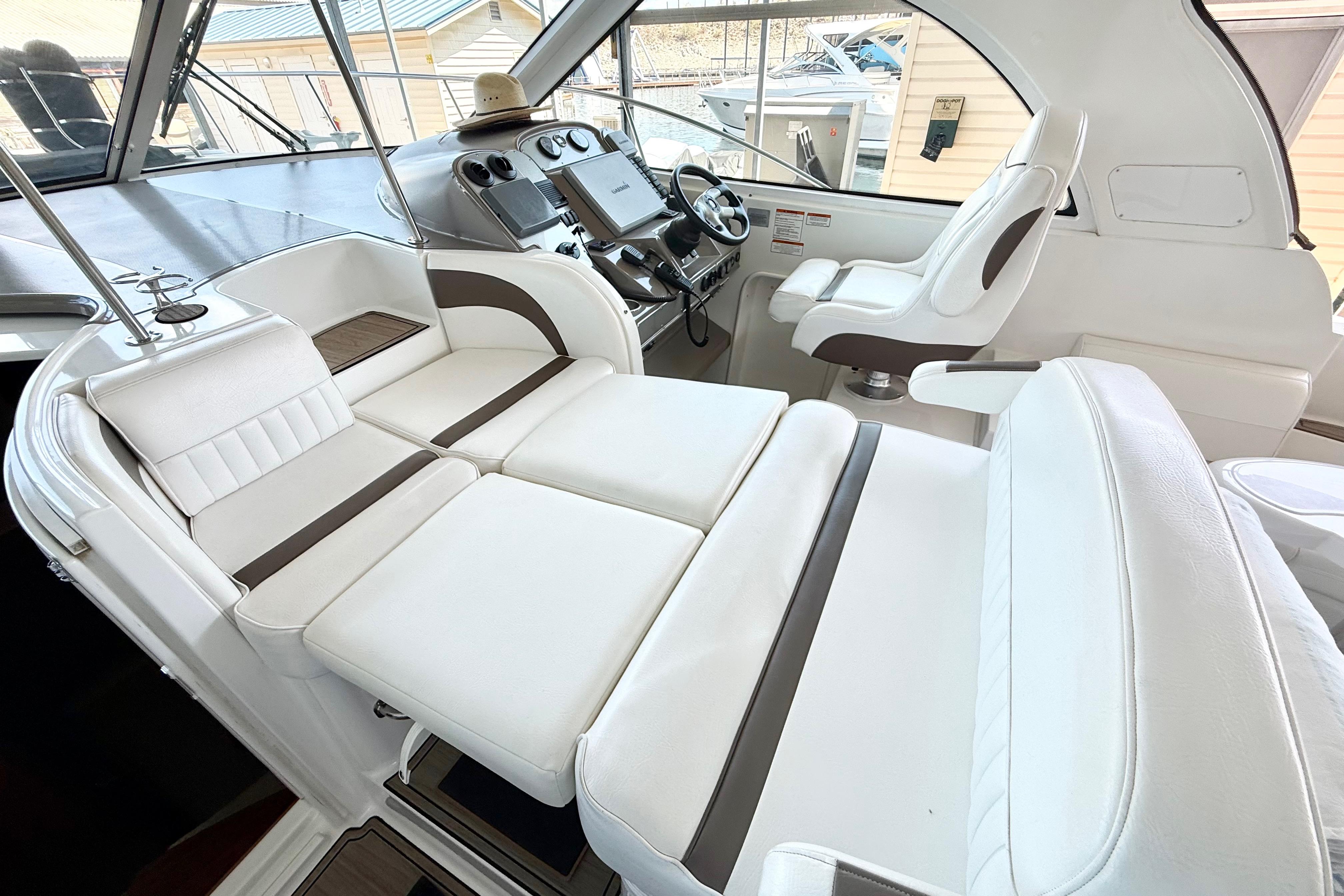 Interior of 2011 Cruisers Yachts 390 Sports Coupe with white seating and helm station.