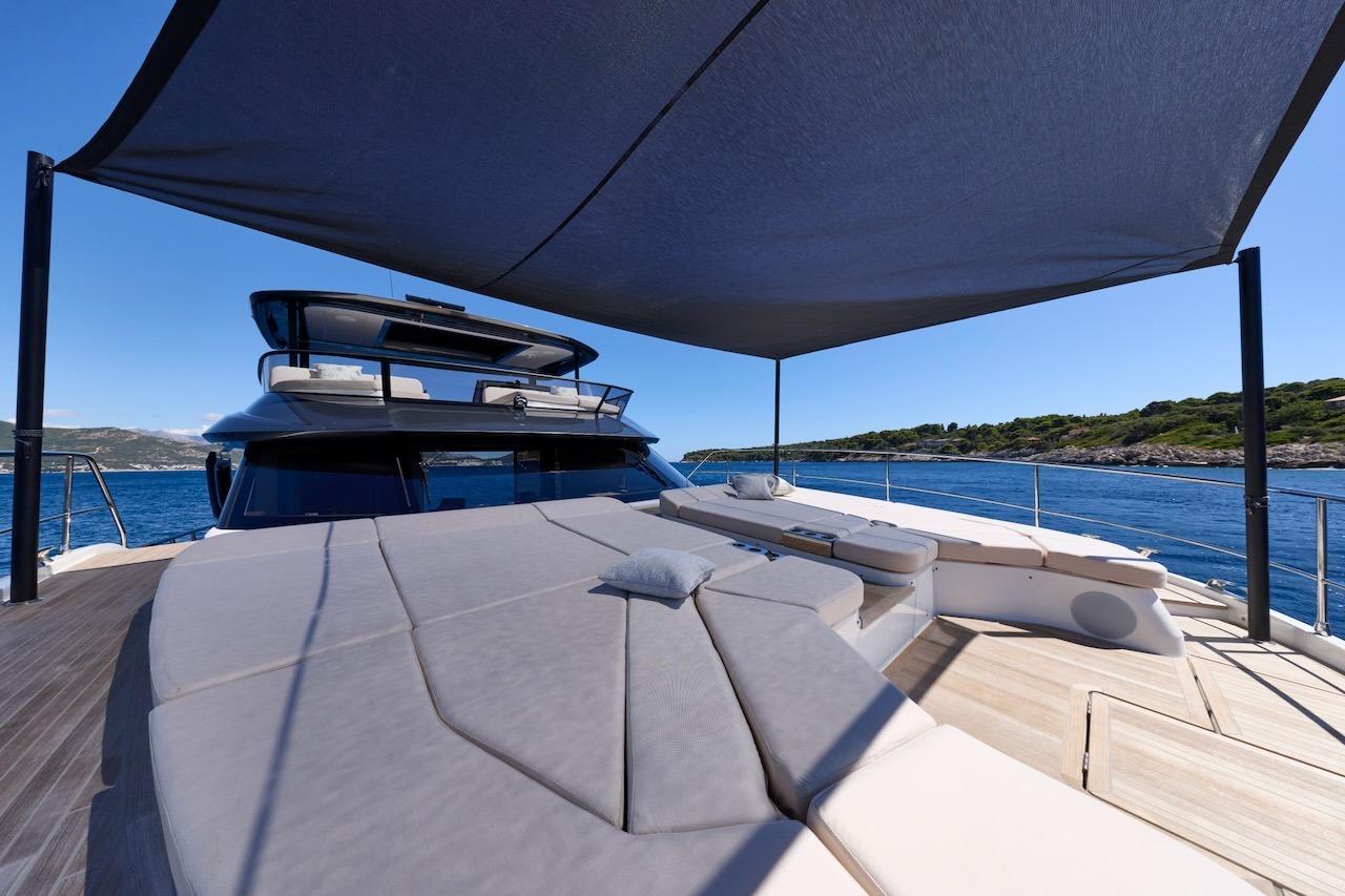 Luxurious 2025 Prestige M7 yacht deck with sunshade, overlooking serene blue waters.