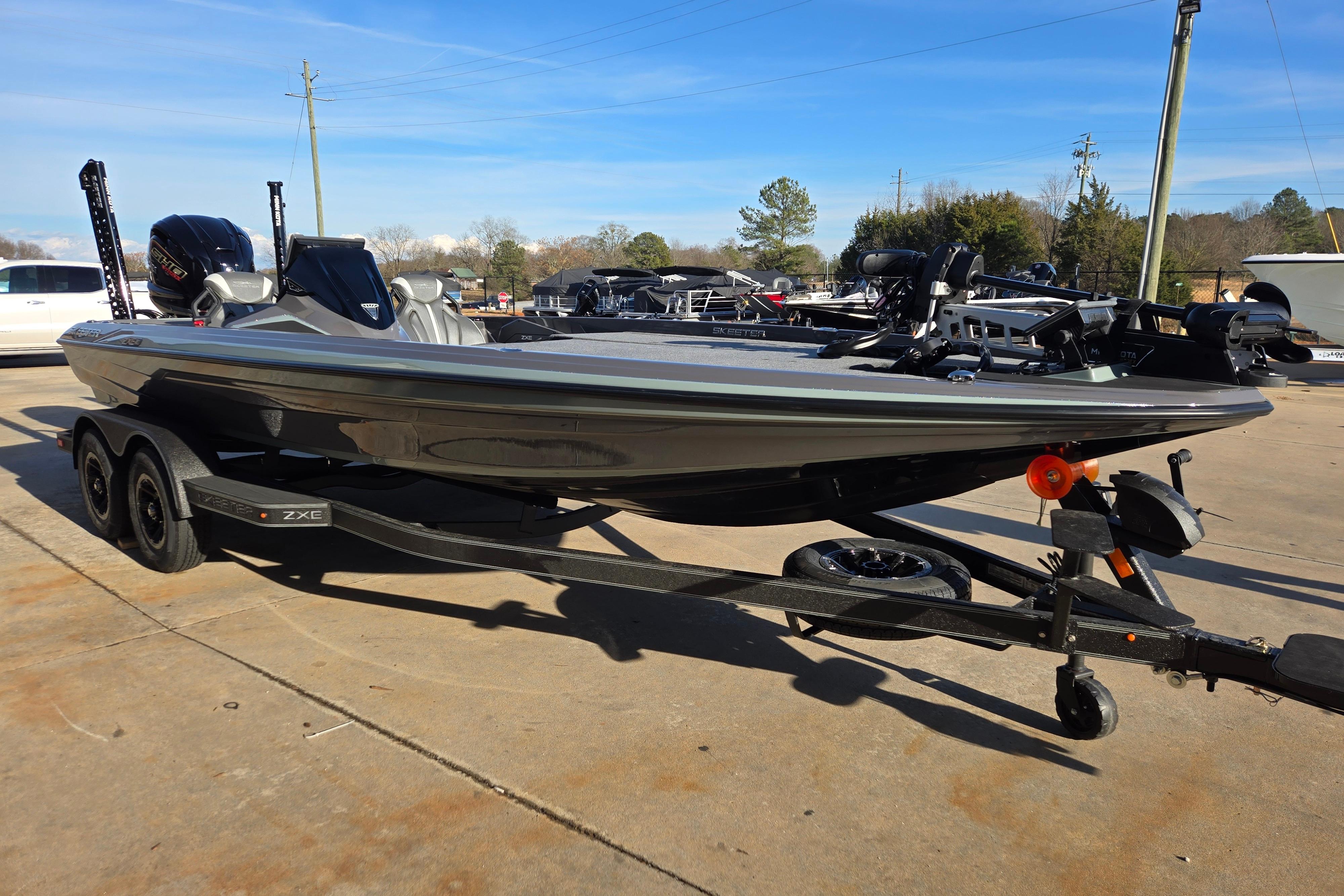 2026 Skeeter ZXE21 bass boat on trailer, parked outdoors under clear blue sky.