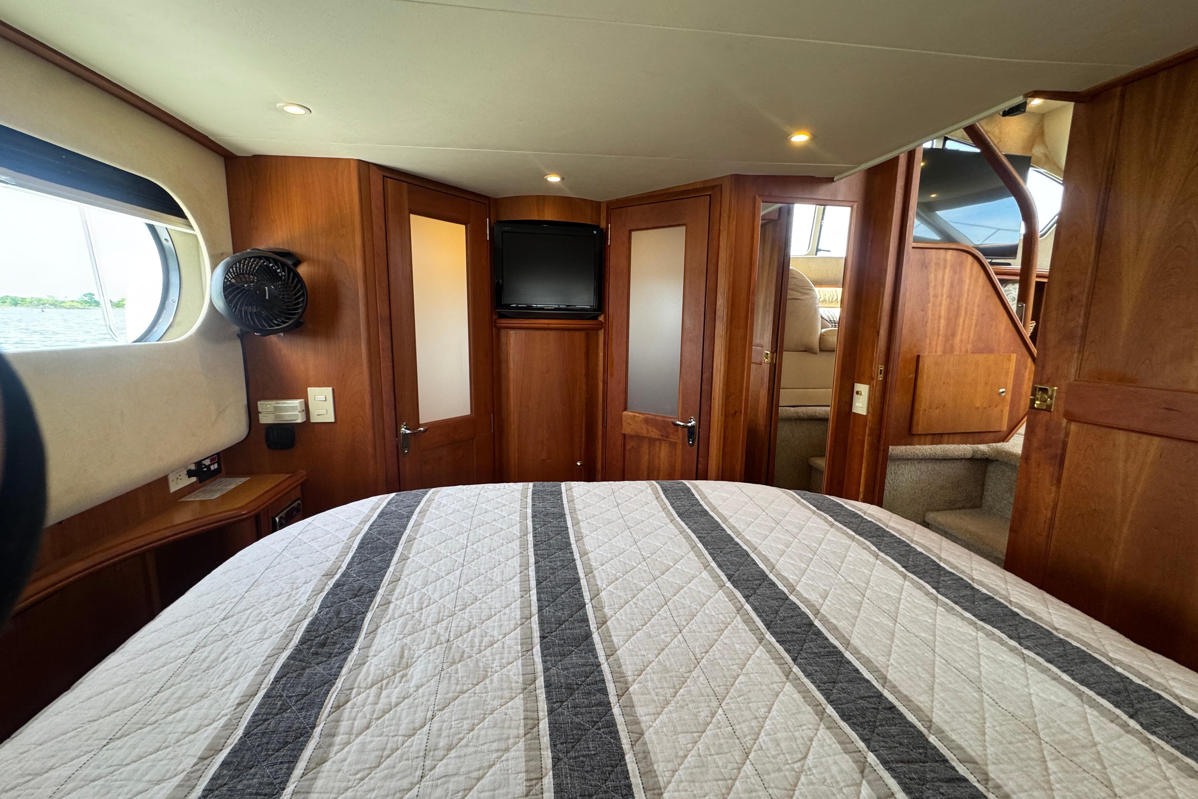 Interior of 2003 Silverton 39 Motor Yacht with cozy bedroom and wooden accents.