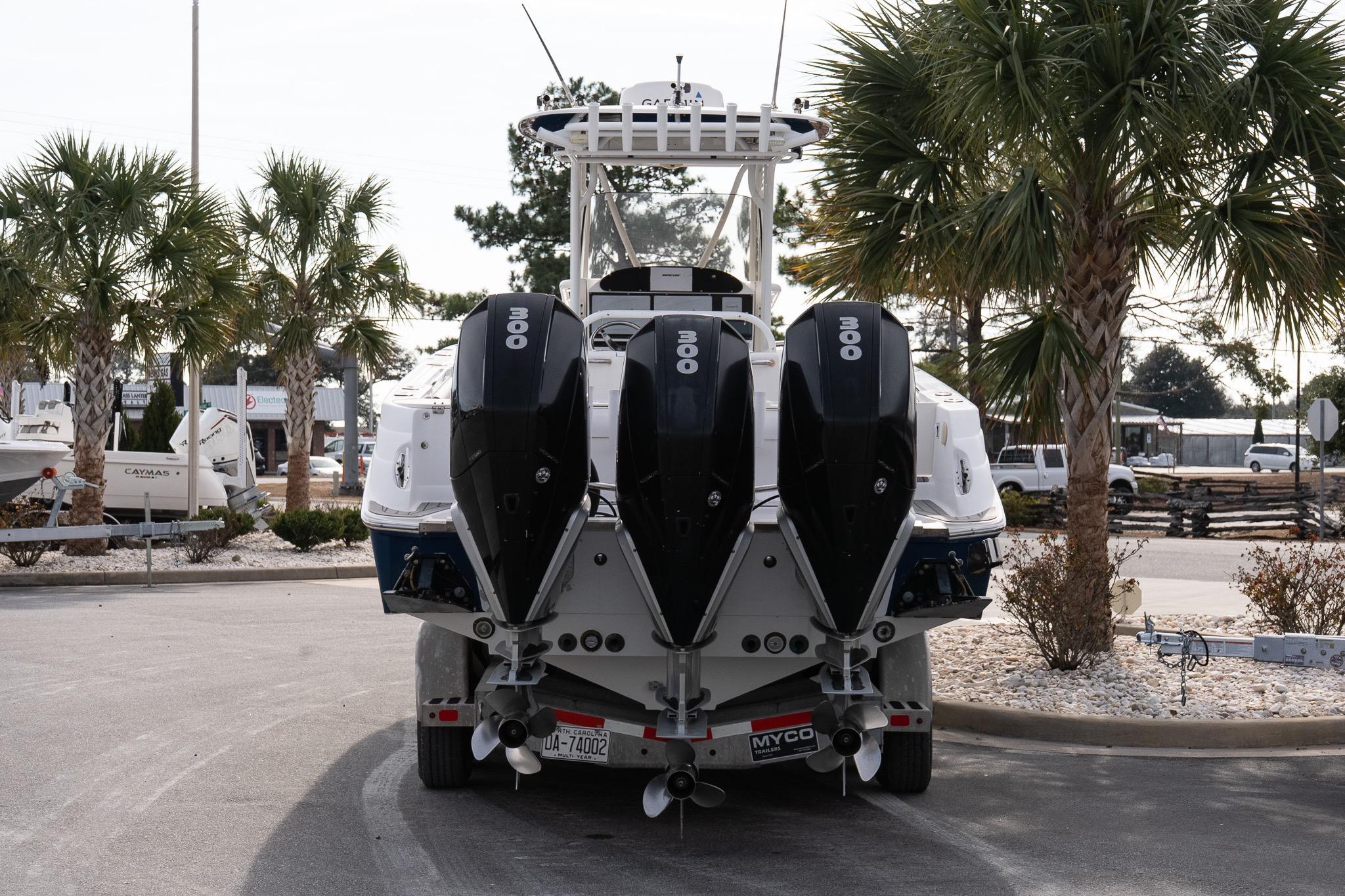 2007 Wellcraft 35 Tournament boat with triple 300 horsepower engines, parked near palm trees.