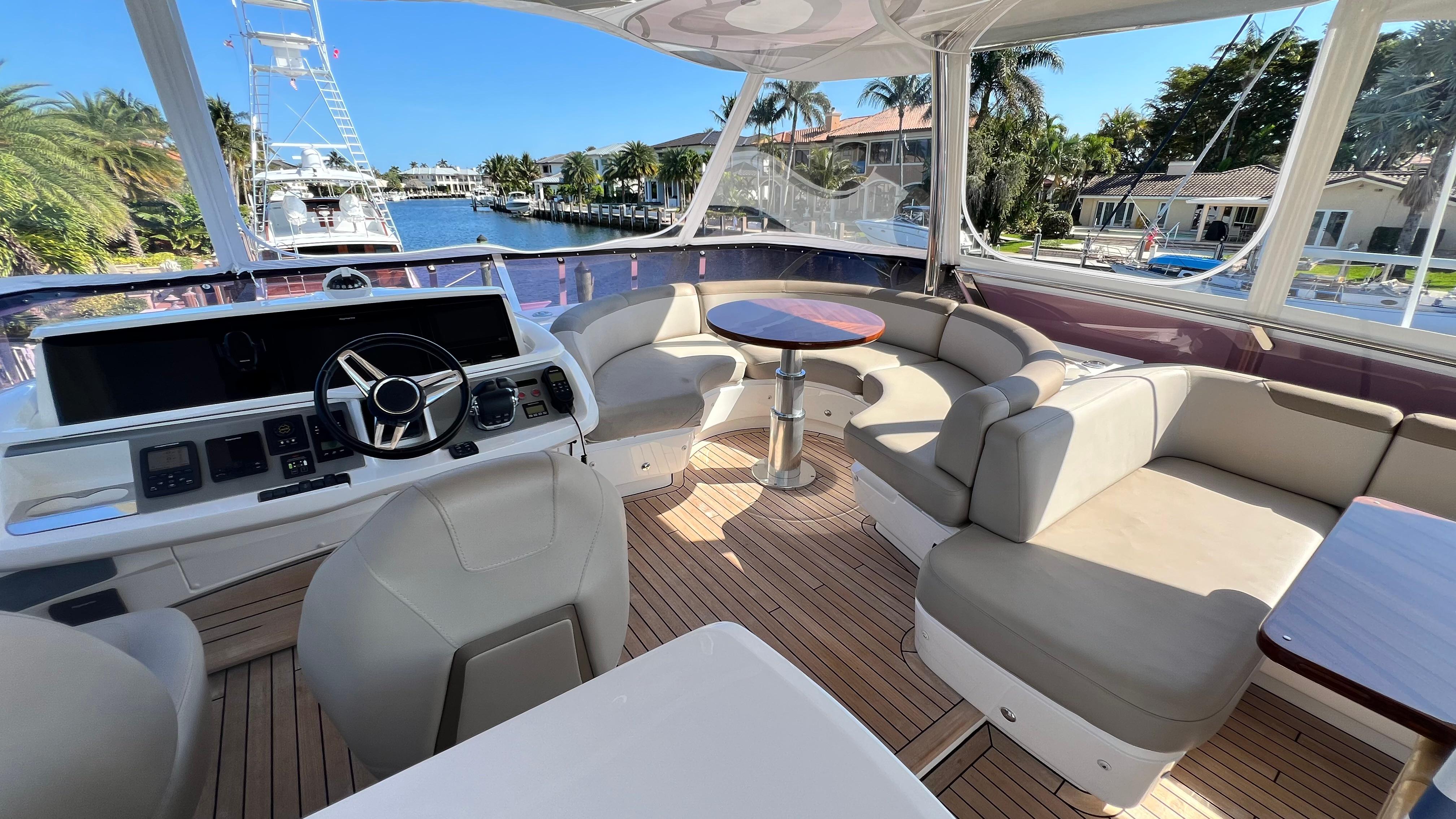 Luxurious 2019 Princess F62 yacht interior with helm, seating, and scenic waterfront view.