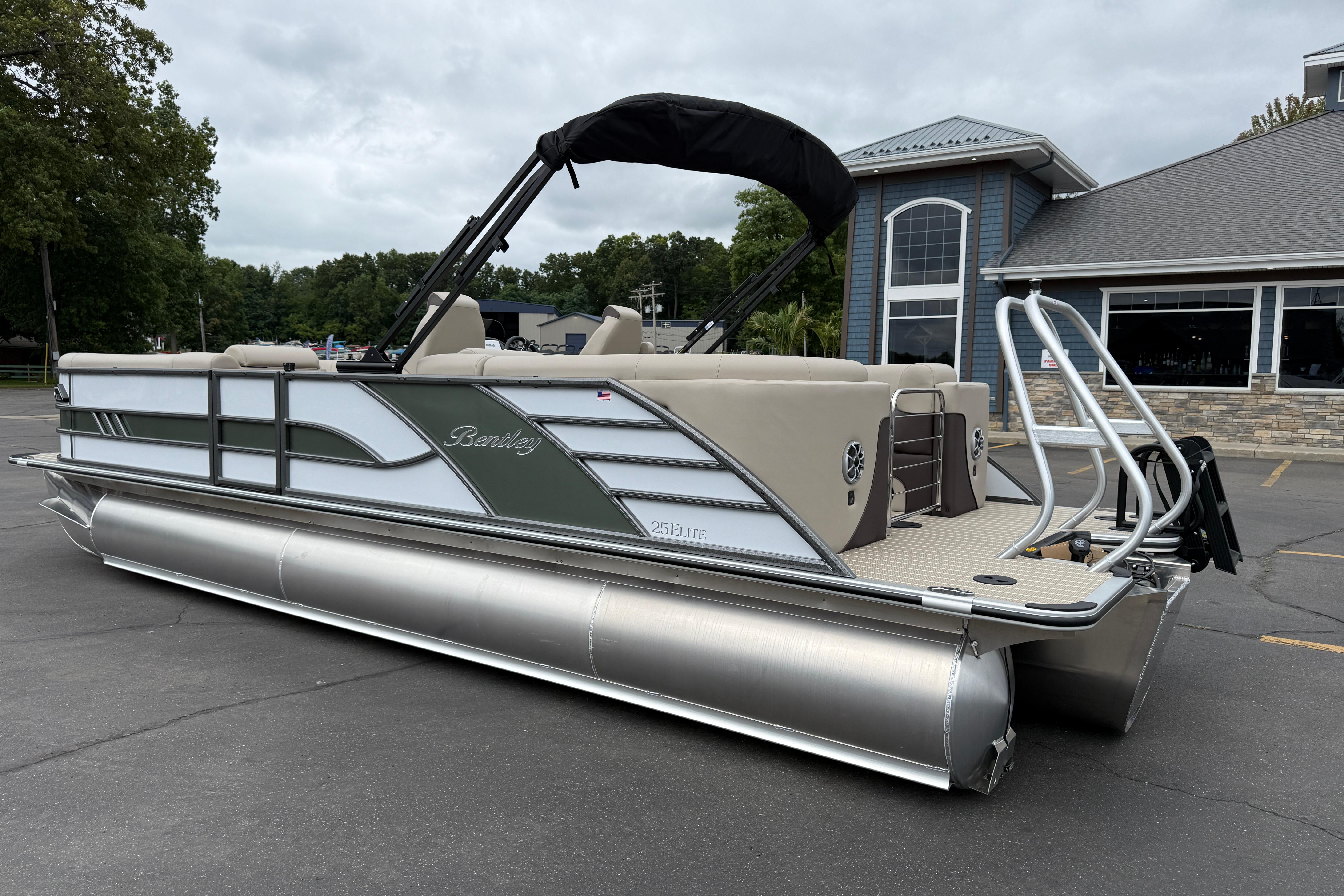 2026 Bentley Pontoons Elite 253 Admiral pontoon boat parked outside a building.