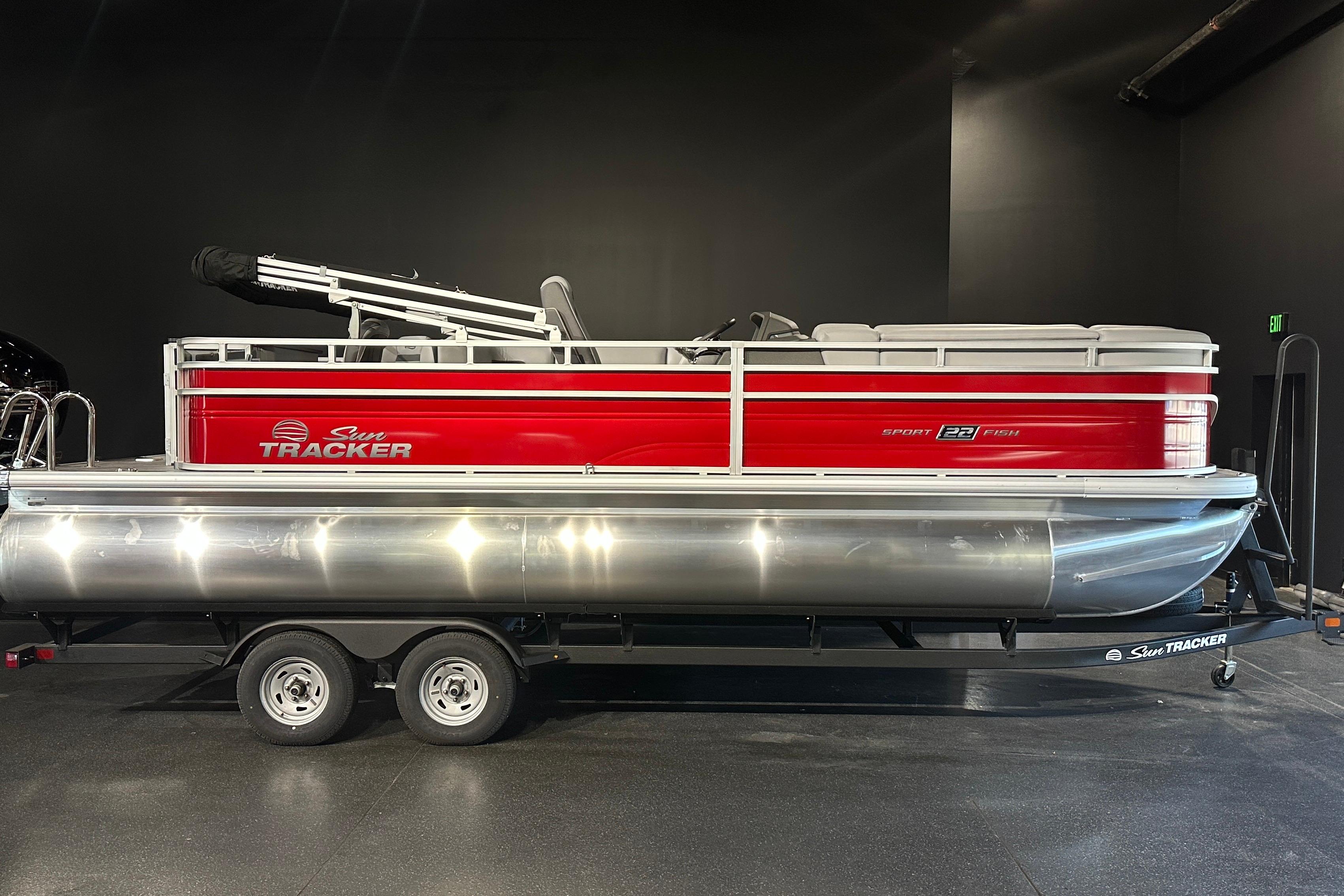 2026 Sun Tracker SportFish 22 DLX pontoon boat with red exterior on trailer.