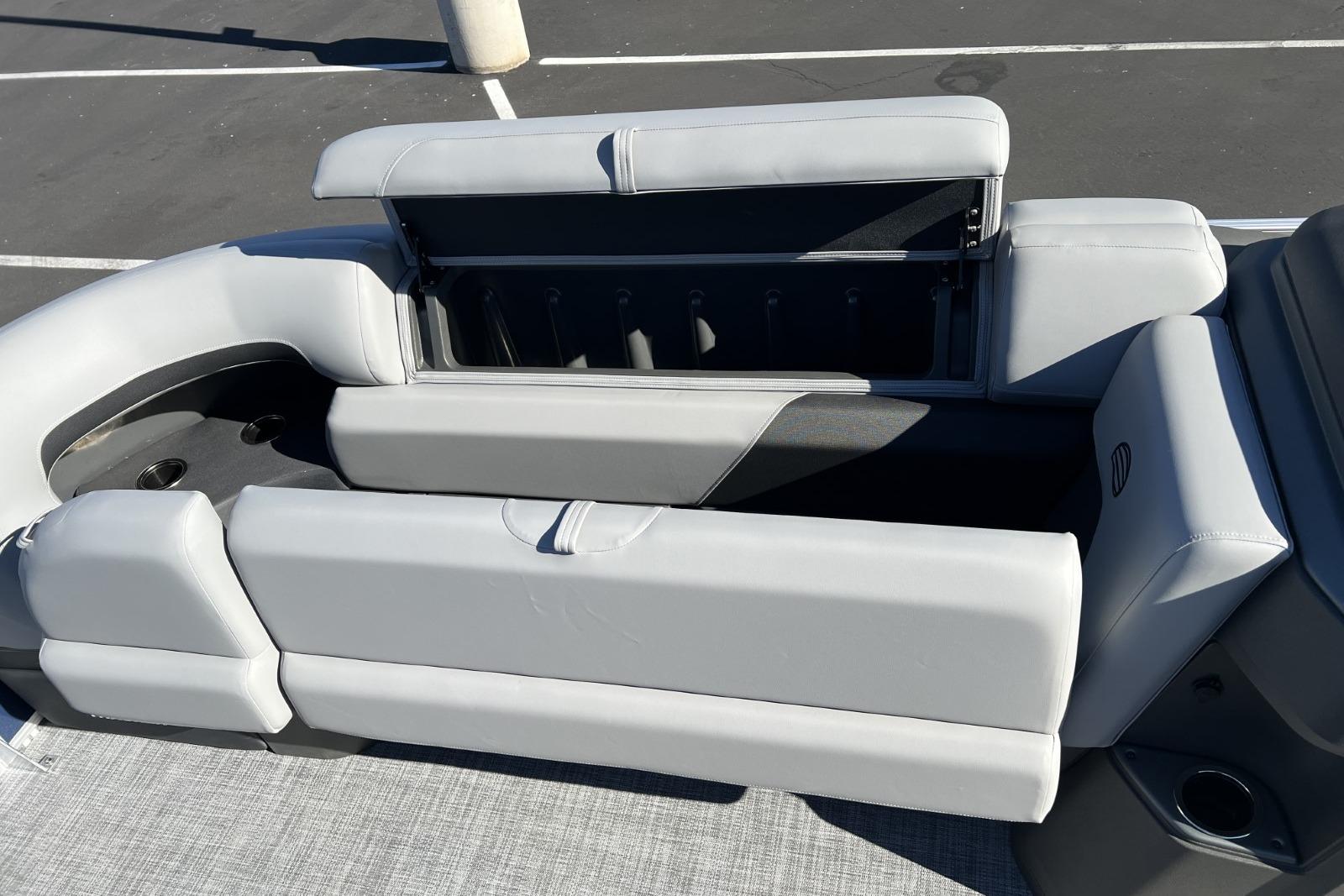 2026 Sun Tracker SportFish 22 DLX boat seating with storage compartment, gray upholstery.