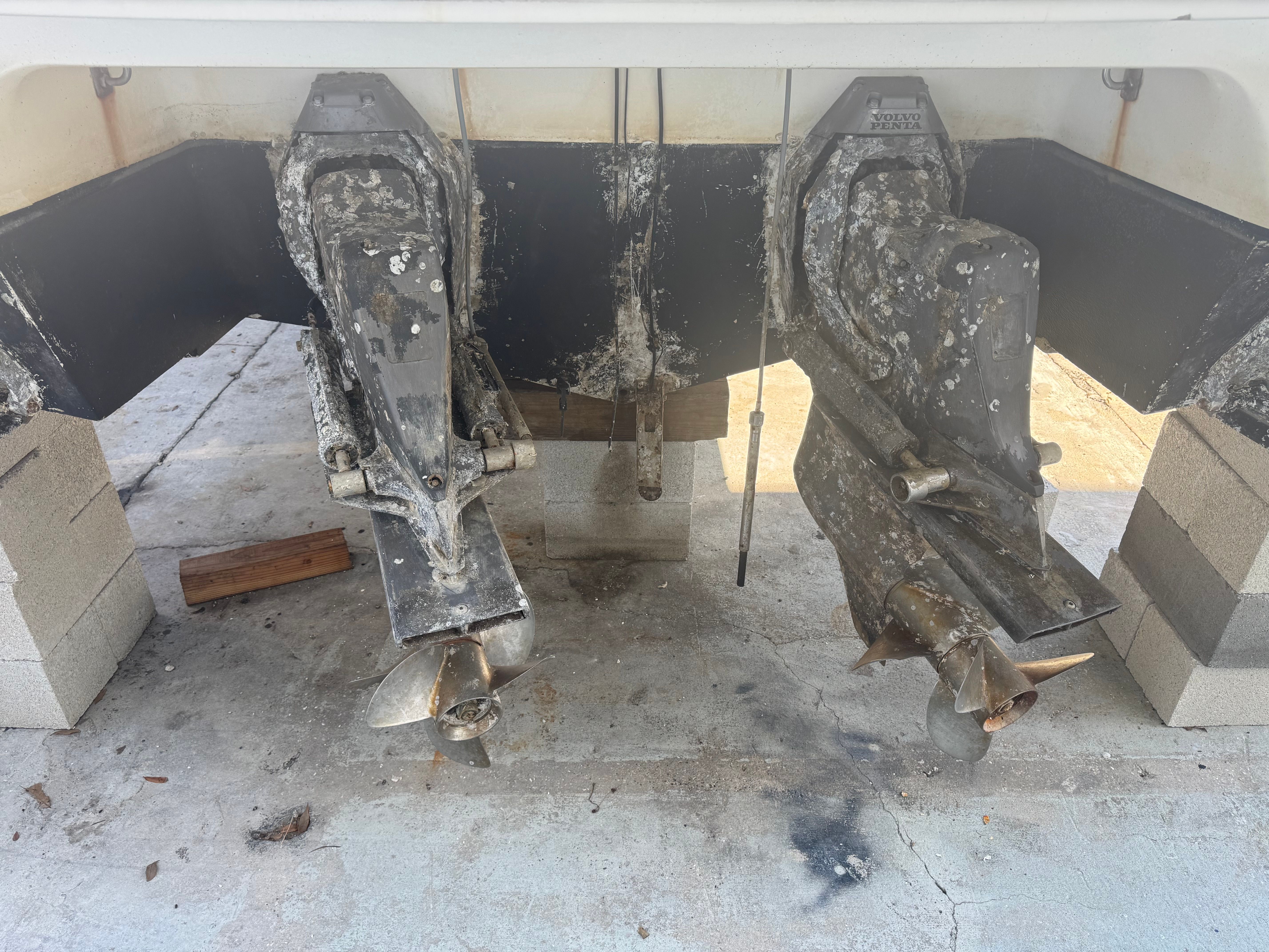 Two boat engines with propellers supported on concrete blocks.