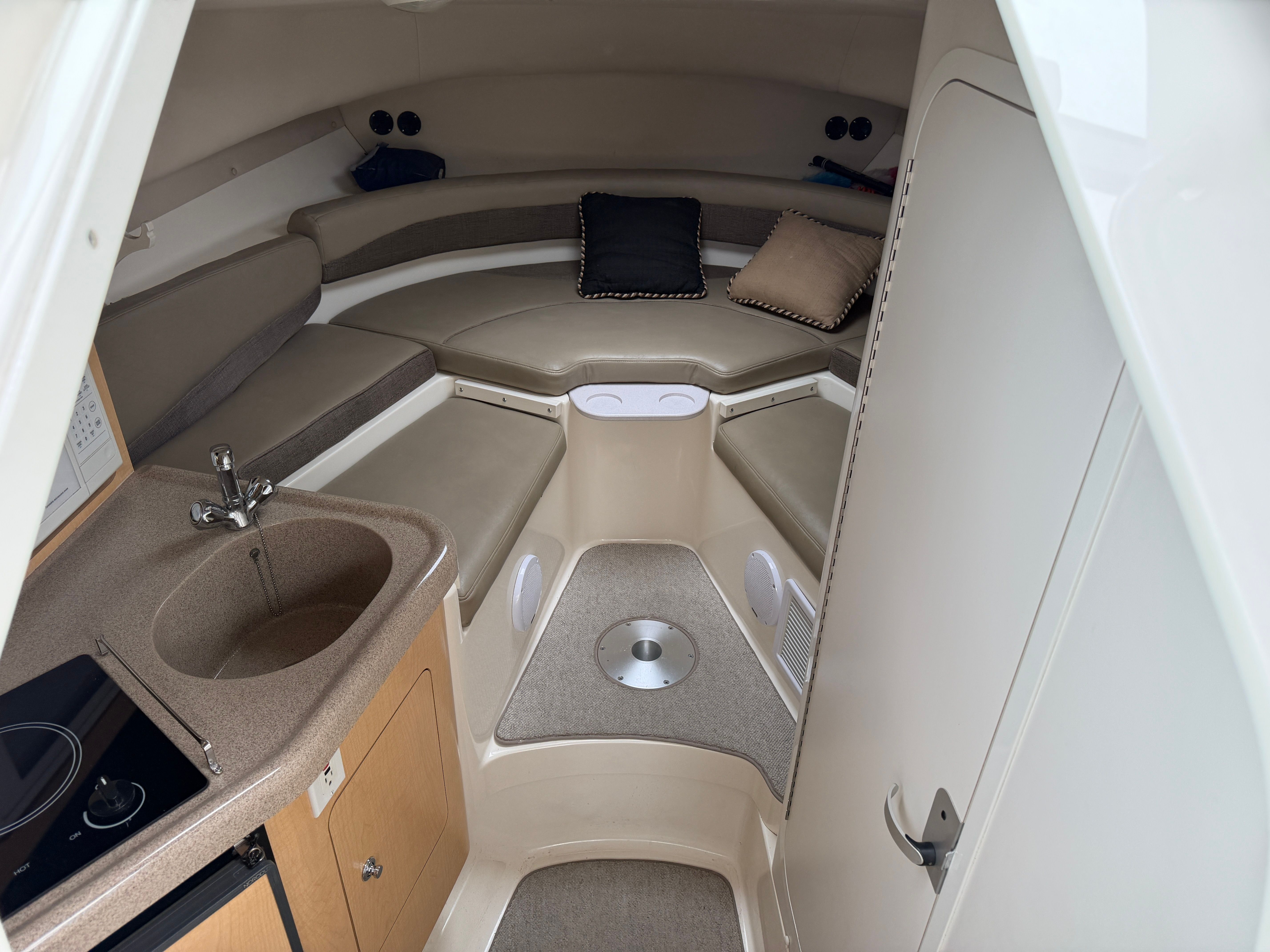 Interior of a 2001 Boston Whaler 26 Conquest with seating area and small kitchenette.