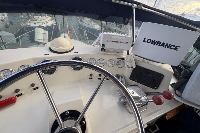 1987 Tollycraft 34 Sundeck Motor Yacht helm with navigation equipment and steering wheel.