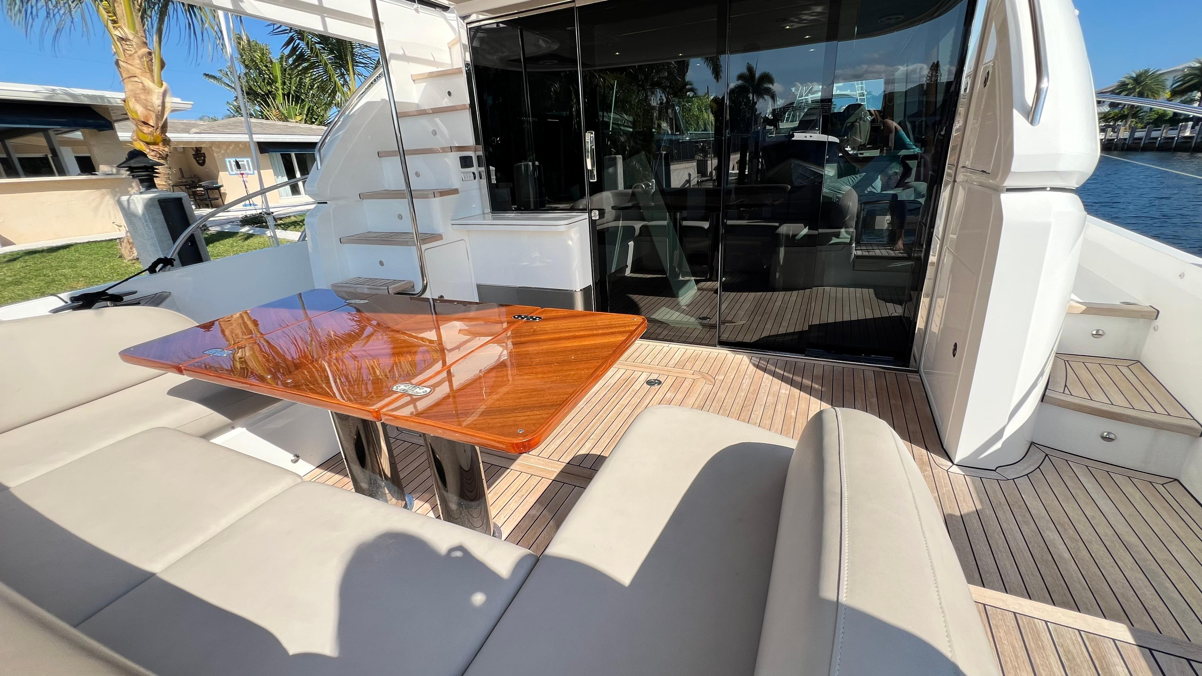 Luxurious 2019 Princess F62 yacht deck with elegant seating and wooden table.