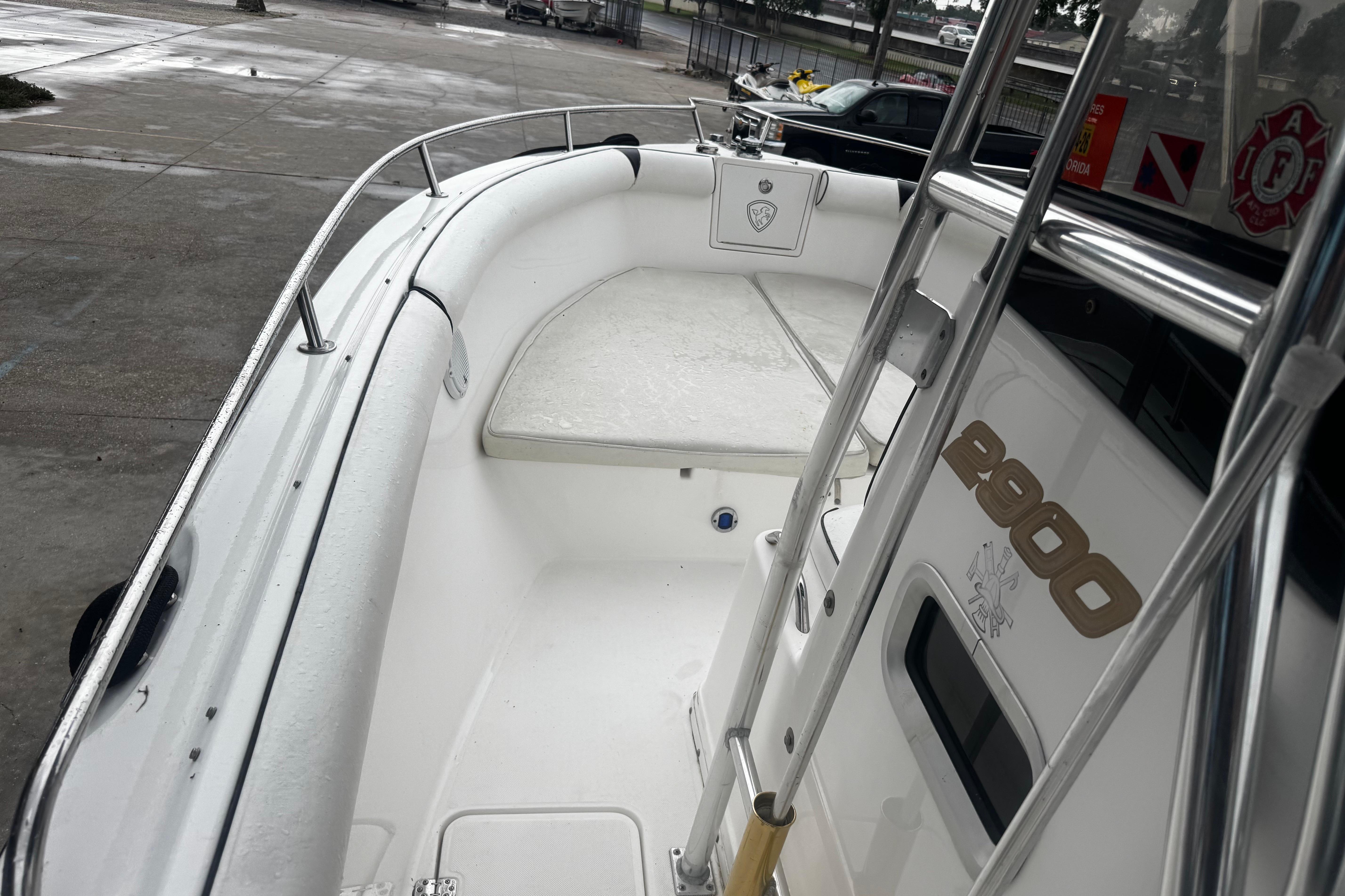 2004 Century 2900 Center Console boat, white interior, docked on a wet surface.