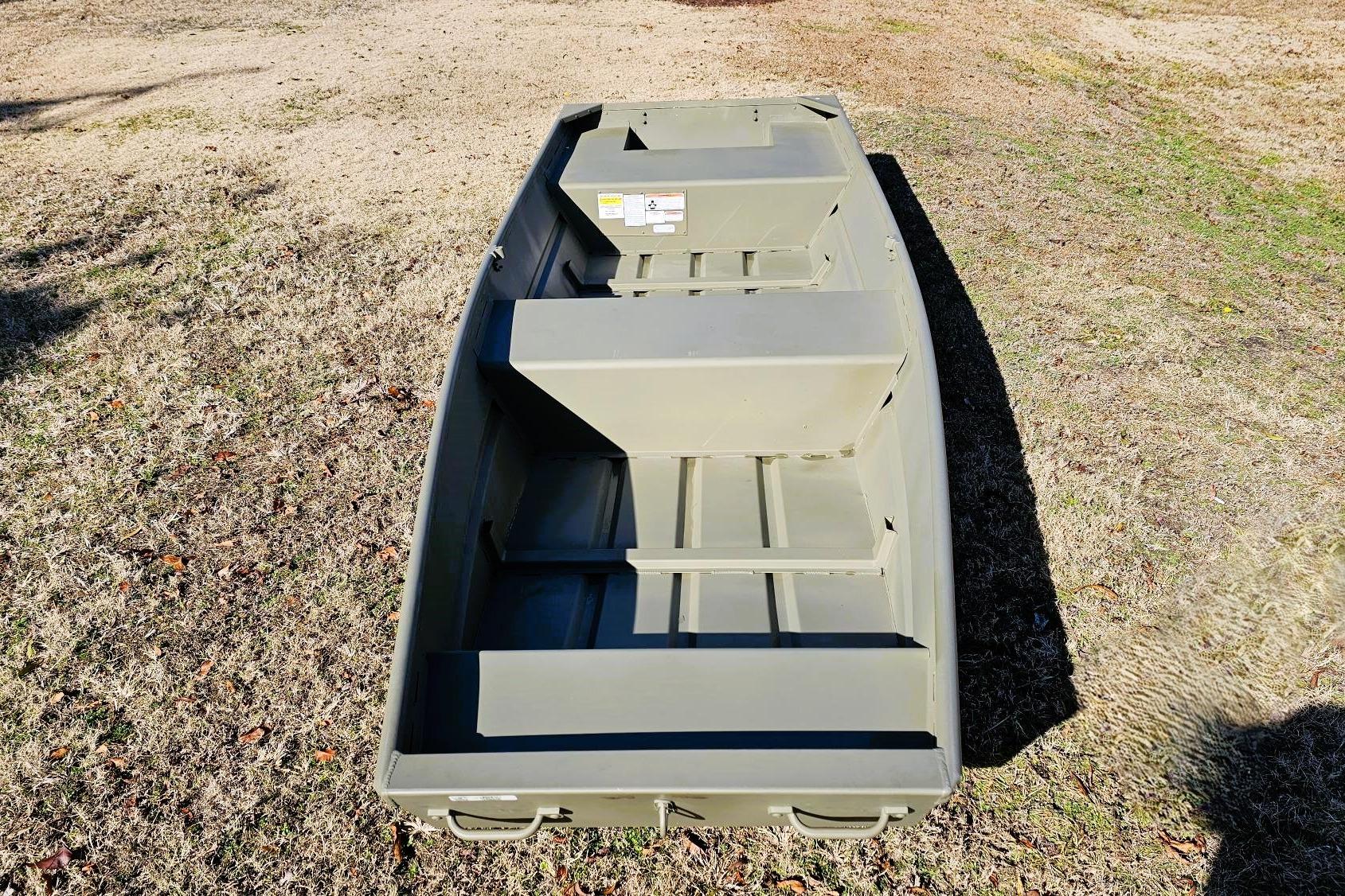 2026 Tracker Grizzly 14 Jon boat on dry grass, showcasing its sturdy design.