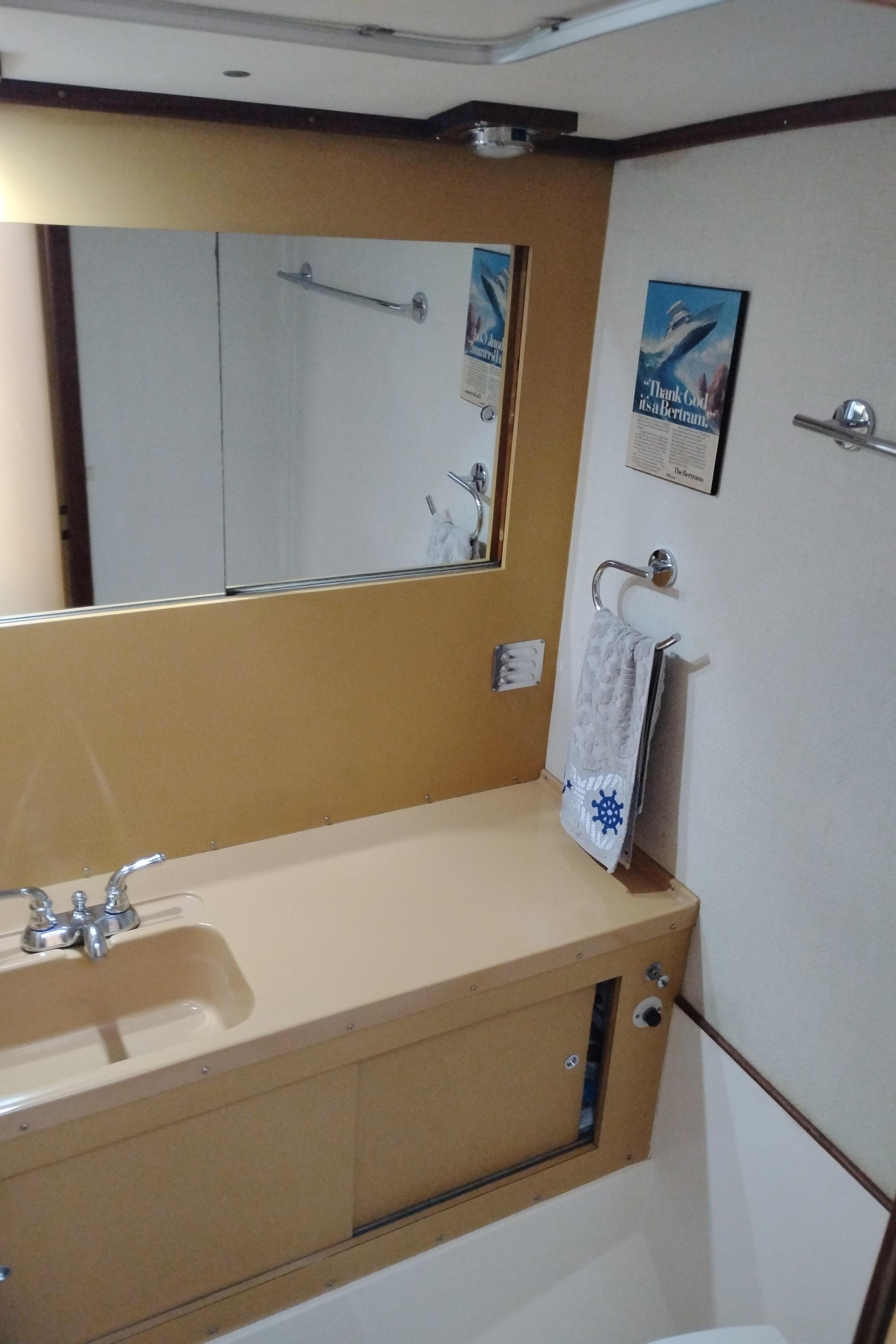 1978 Bertram 33 Convertible bathroom with sink, mirror, and towel rack.