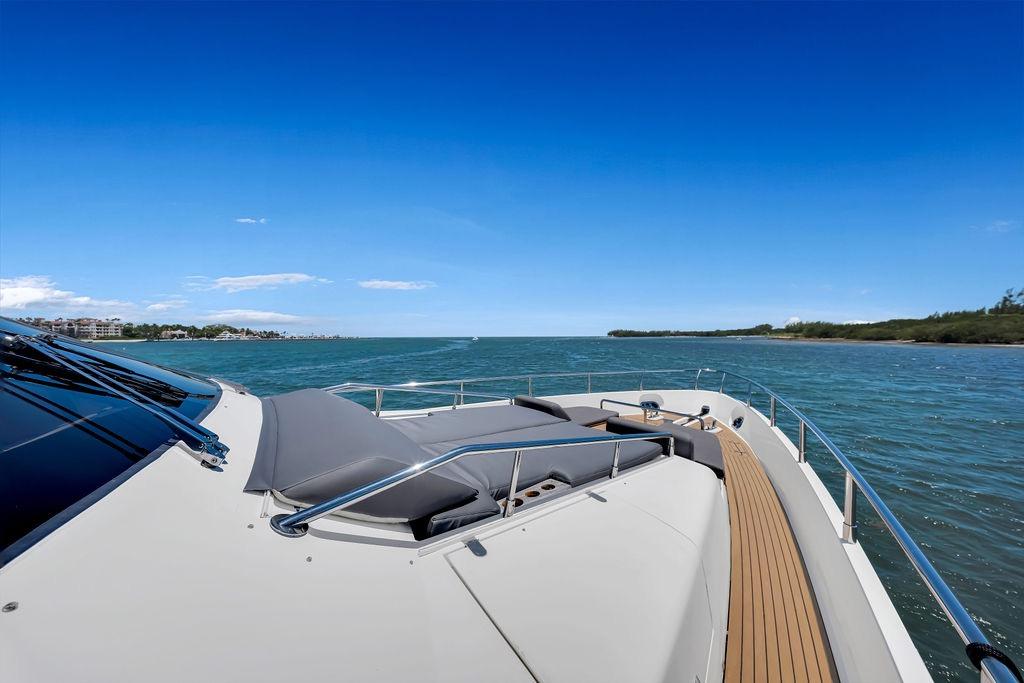 Luxury yacht Aicon 75 cruising on open water under clear blue sky.