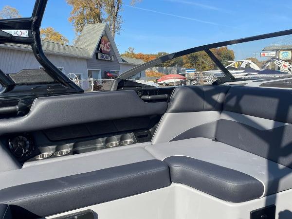 2025 Moomba Mondo boat interior with sleek black and gray seating, outdoor dealership view.