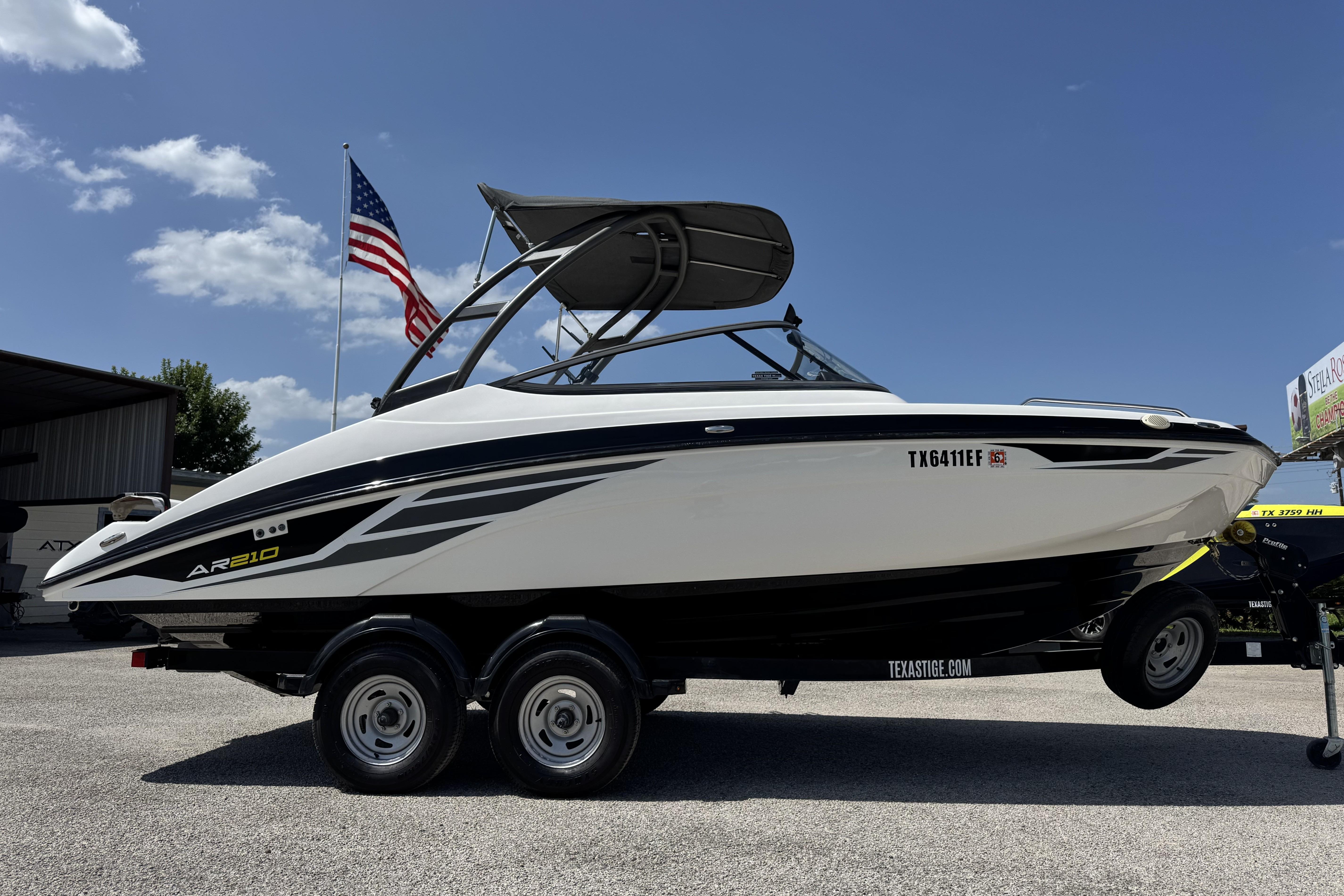 2018 Yamaha AR210 boat on trailer, American flag in background, sunny day.