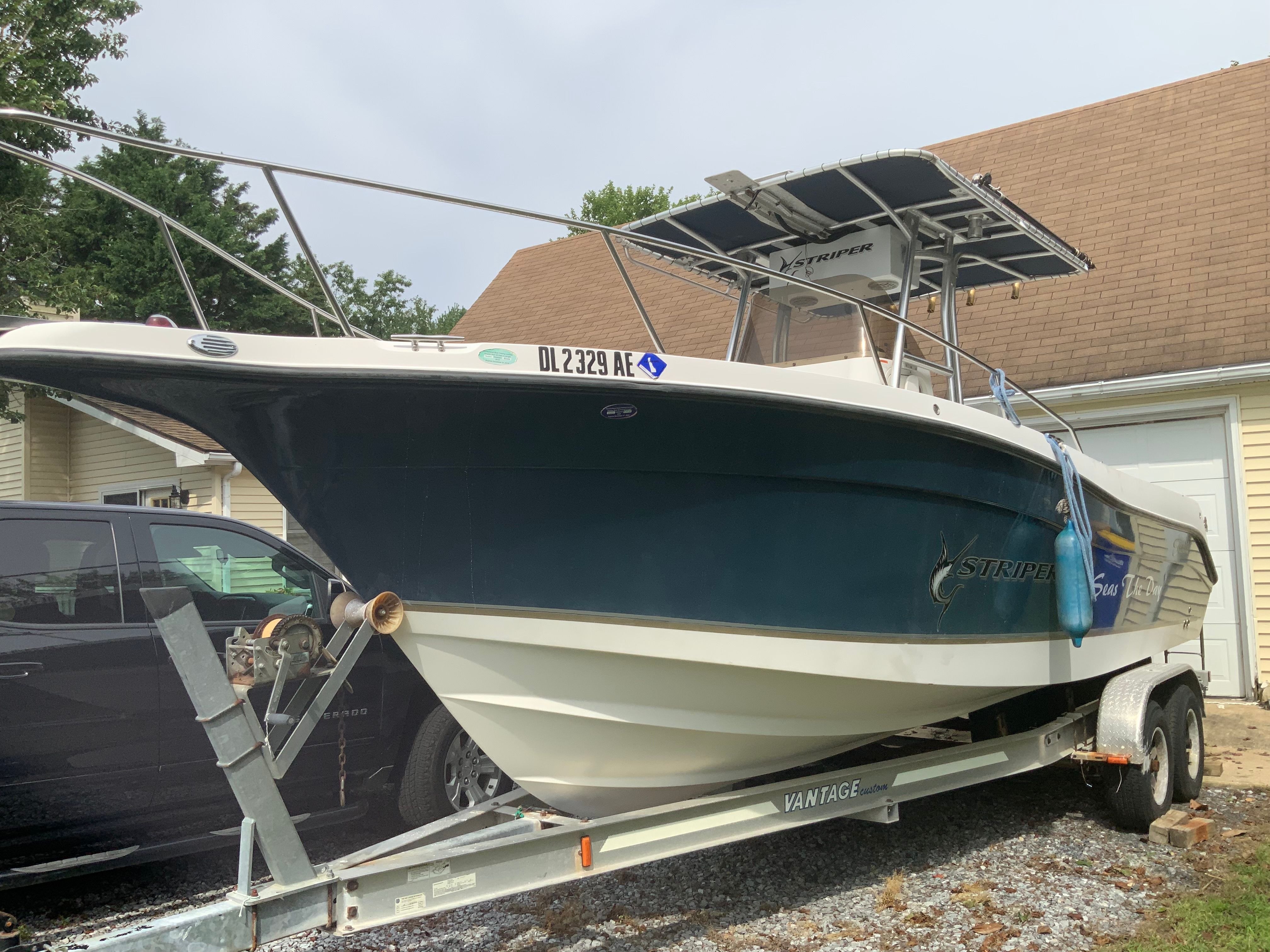 A 2006 Seaswirl Striper 26 on a trailer, parked next to a building.