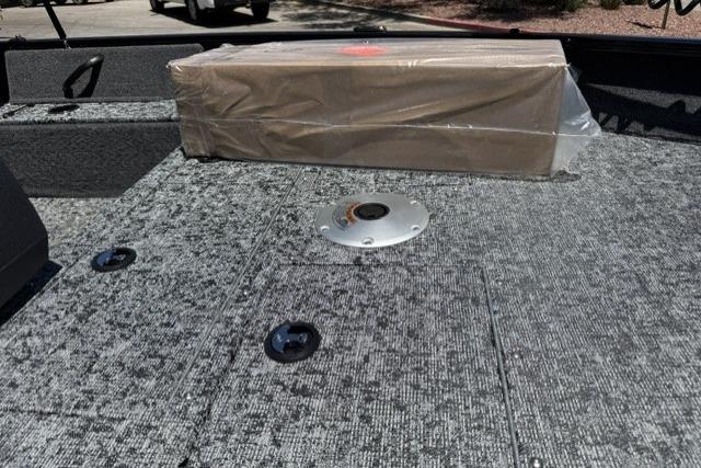 2026 Tracker Pro Guide V-16 SC boat deck with packaged item on textured surface.