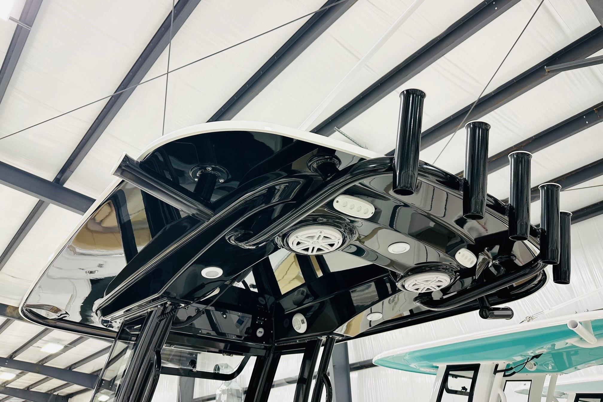 2026 Sportsman Open 232 Center Console boat with sleek black T-top and rod holders.