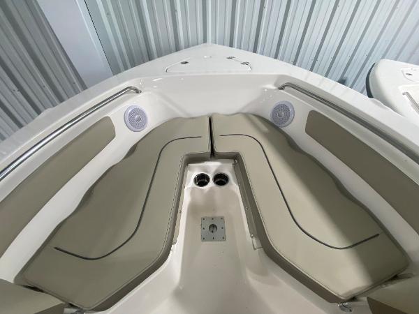 2024 Key West 203 FS boat bow seating area with beige cushions.