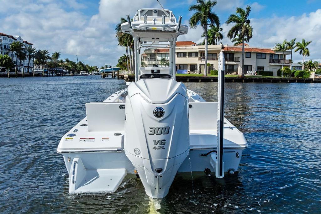 2023 Everglades 243 Center Console boat on water, palm trees in background.