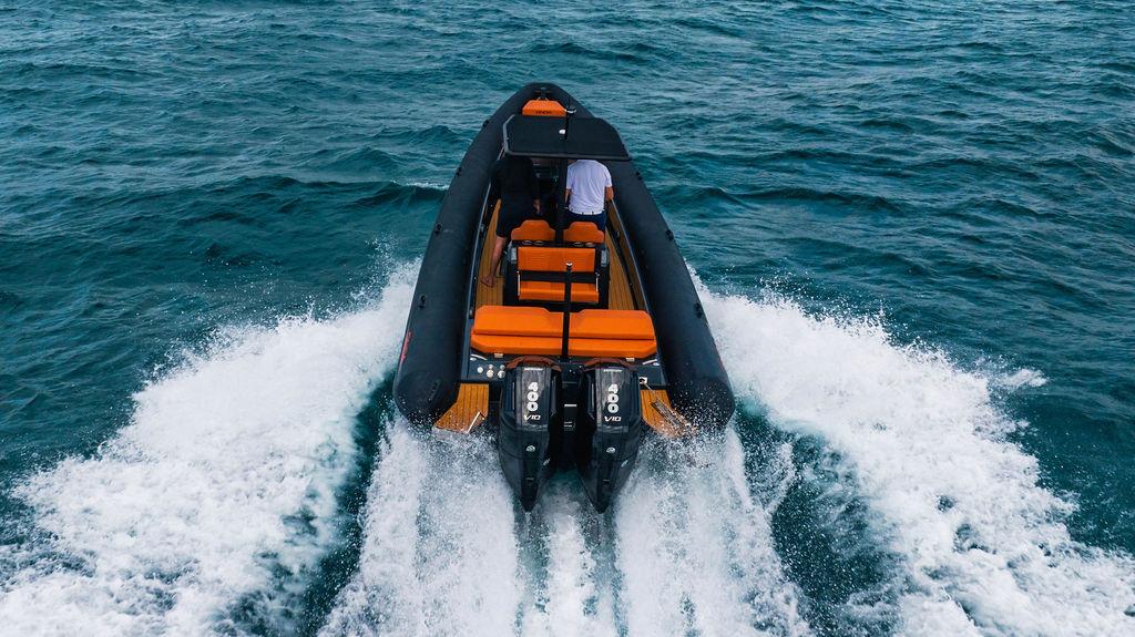 2025 Onda Magna boat speeding on ocean with dual engines, orange seating, and sleek design.