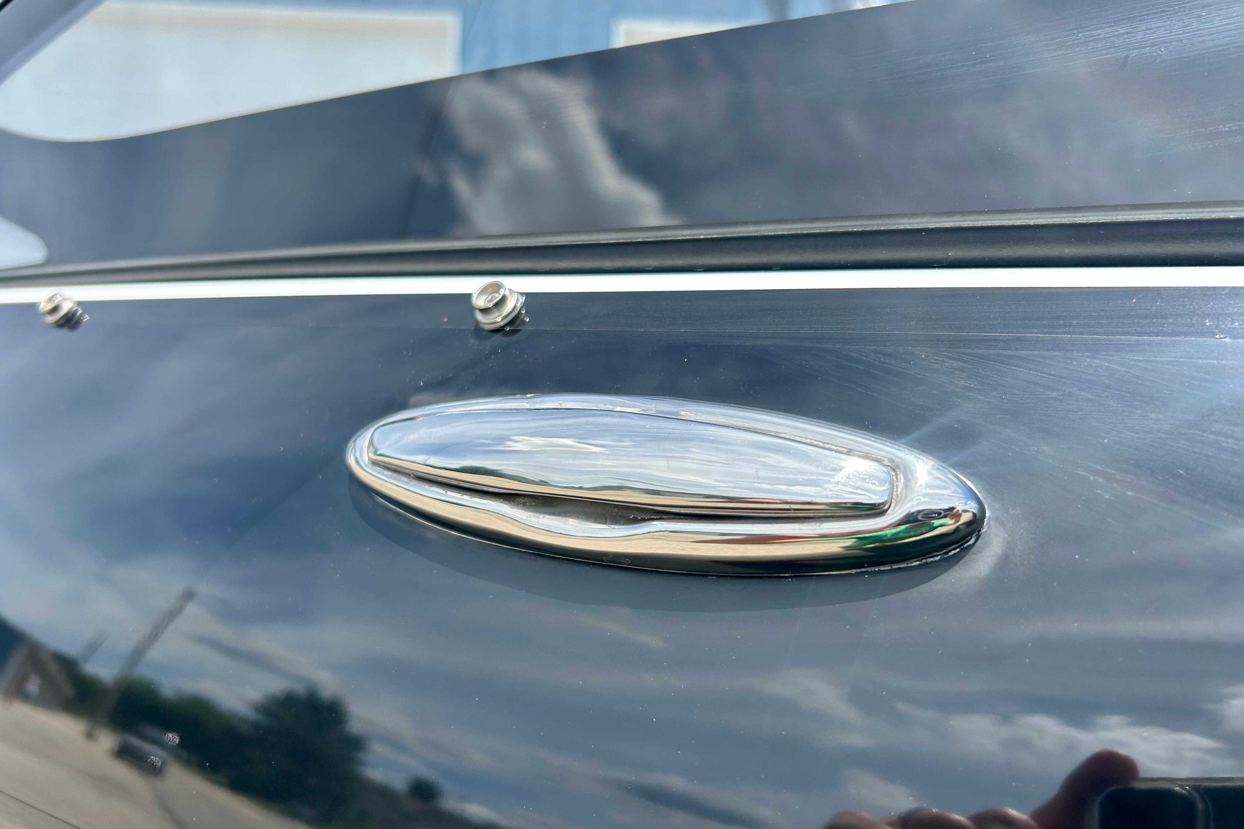 Close-up of a 2021 Scarab 195 ID boat's sleek chrome handle detail.