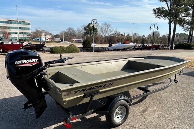 2026 Tracker Grizzly 1860 Utility boat with Mercury engine on trailer, parked outdoors.