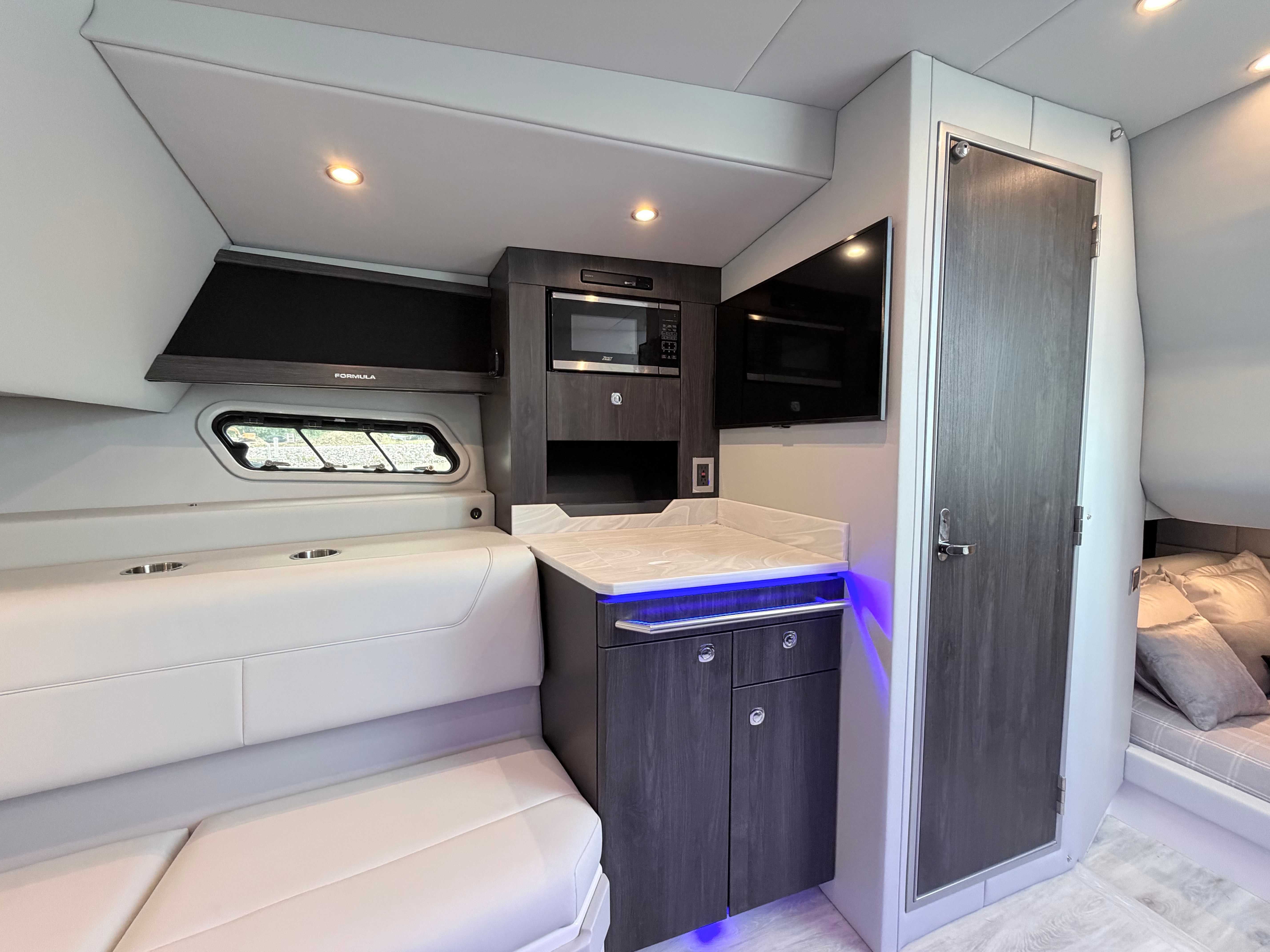 Interior of a modern yacht with sleek kitchen and cozy seating area.