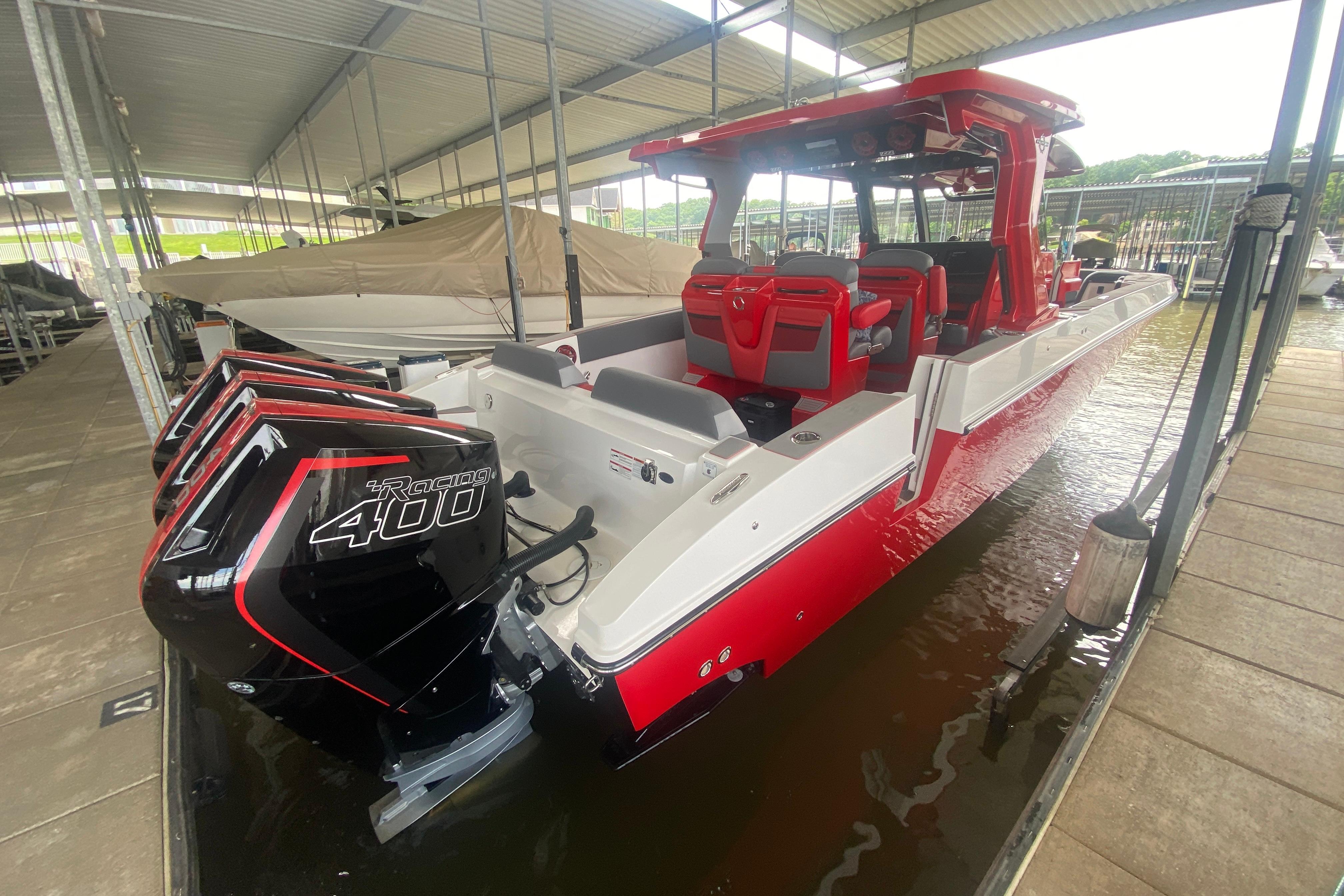 2025 Fountain 38 SCX boat with triple Racing 400 engines, docked in a covered marina.