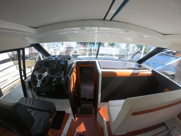 2017 Jeanneau NC 11 boat interior with helm and seating area.