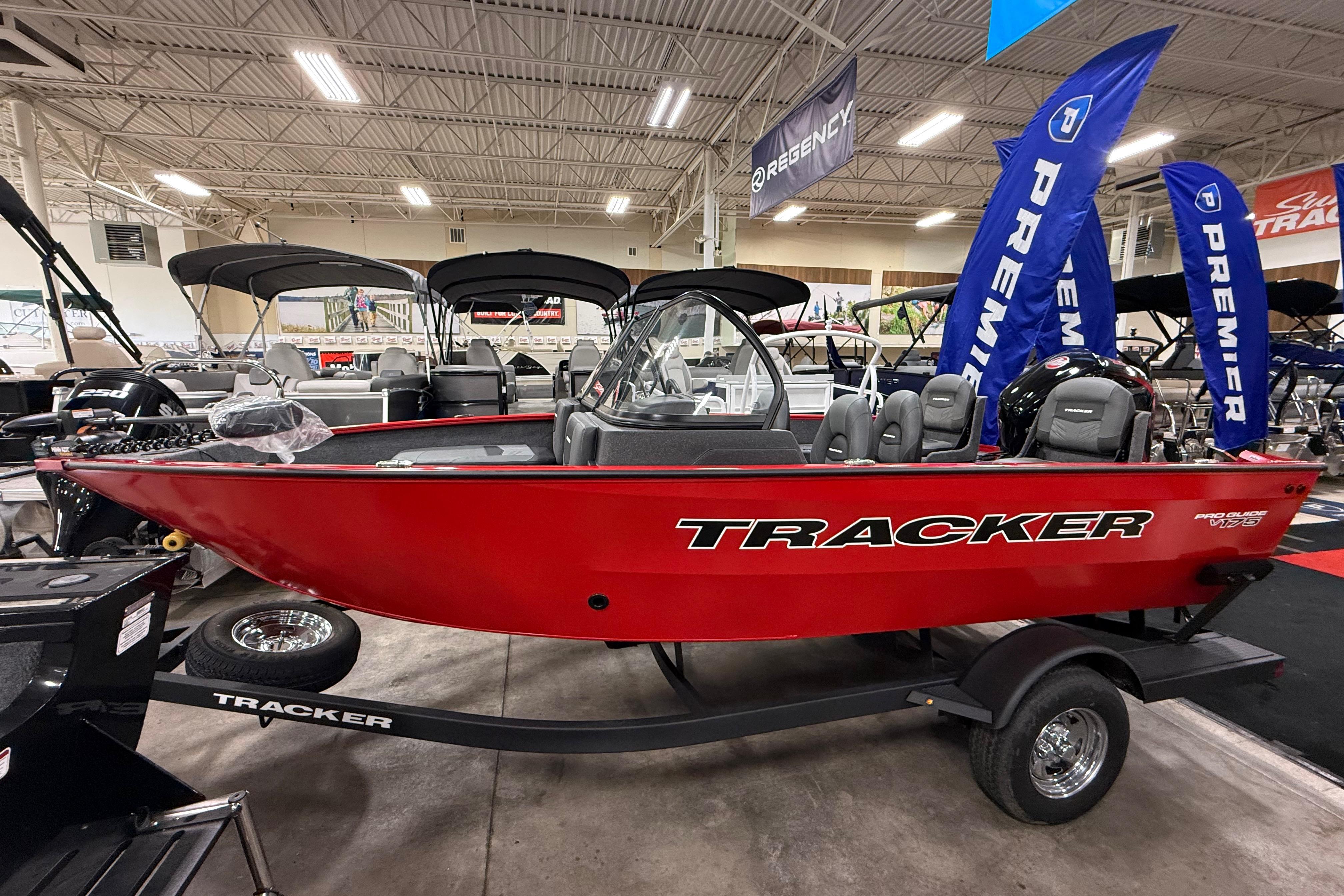 2026 Tracker Pro Guide V-175 Combo boat displayed indoors, featuring a sleek red design.