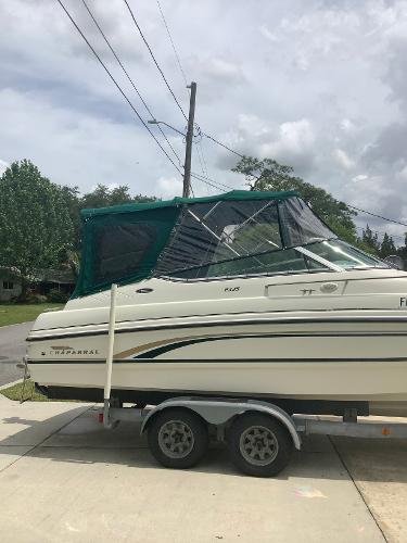 1998 Chaparral 2335 SS boat on a trailer with green canopy.