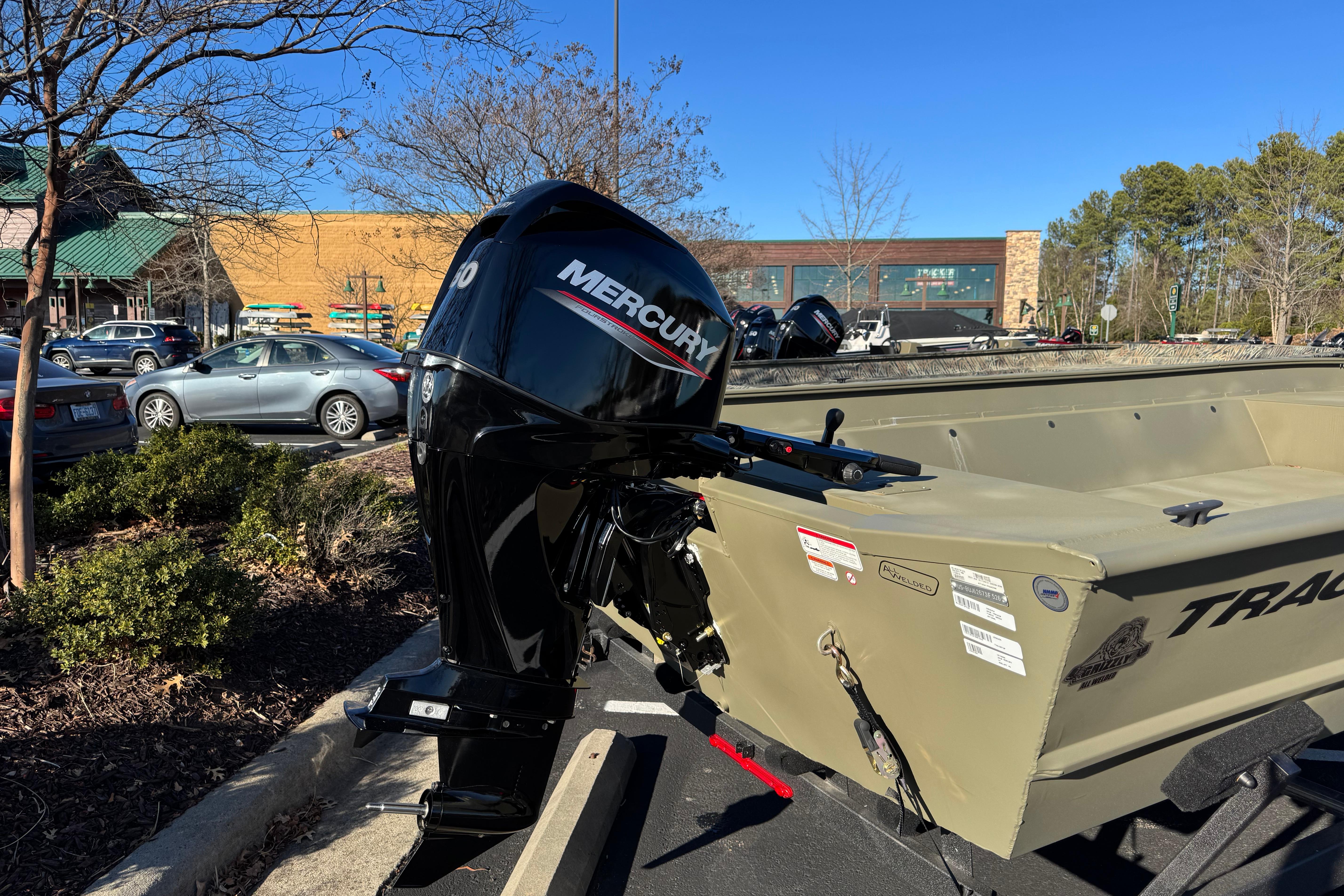 2026 Tracker Grizzly 2072 Utility boat with Mercury outboard motor in parking lot.