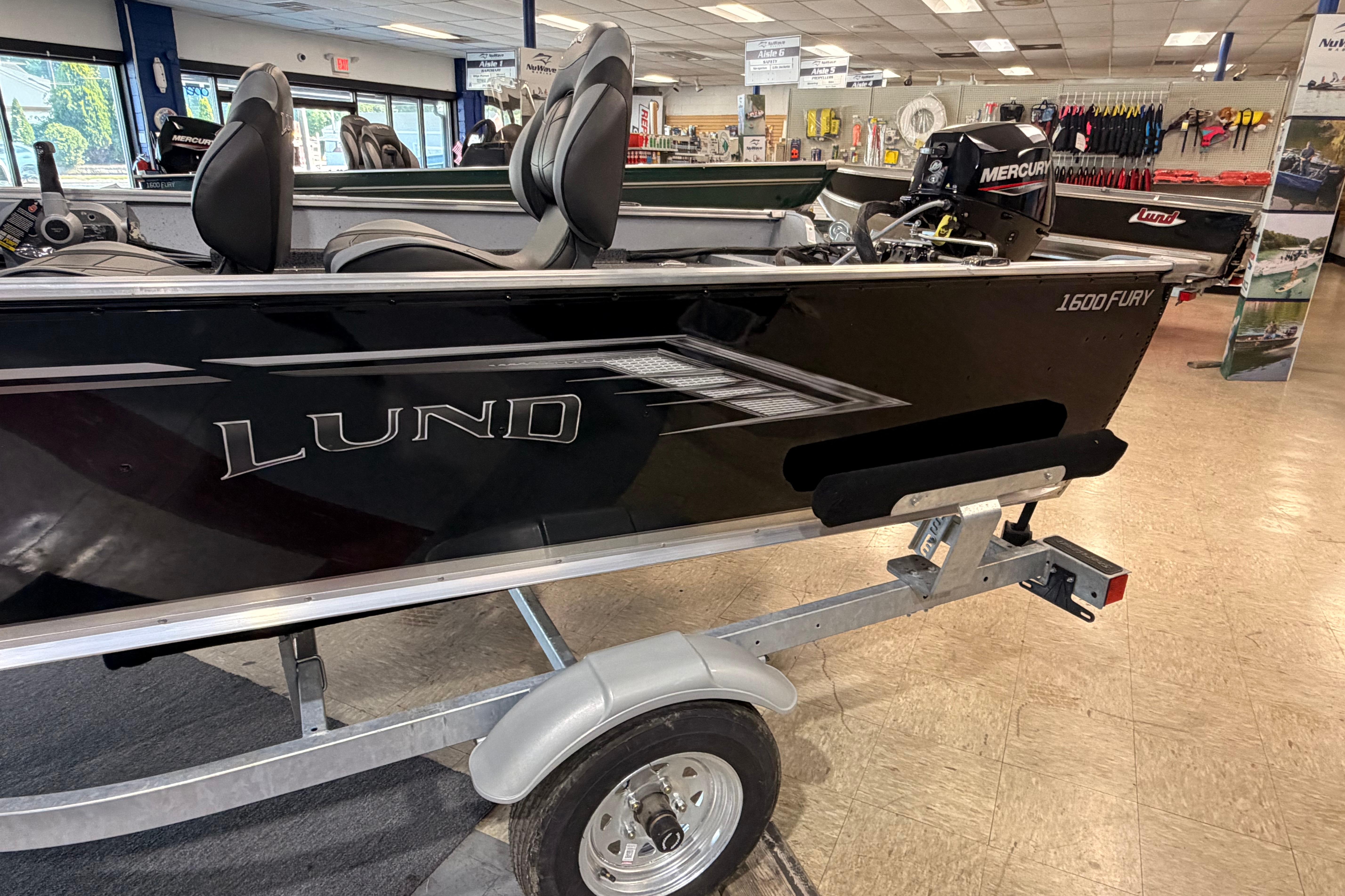 2027 Lund 1600 Fury SS boat on display in showroom with Mercury engine.