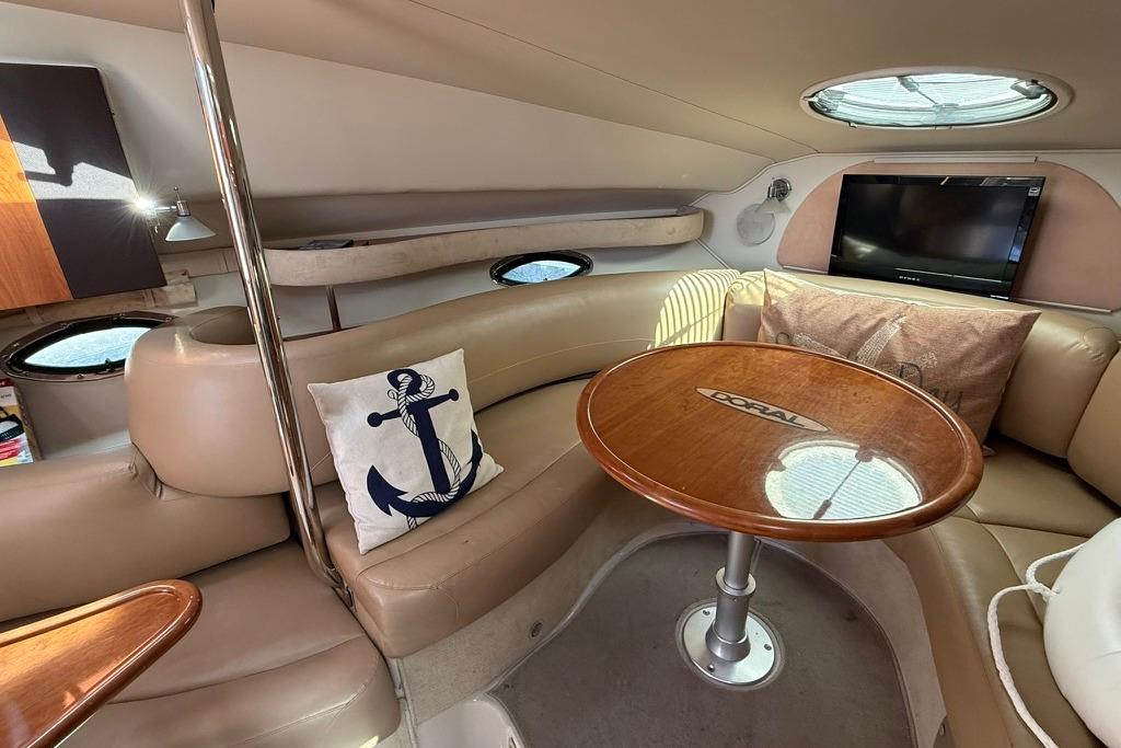 Luxurious 2005 Doral Elegante yacht interior with leather seating, wooden table, and nautical decor.