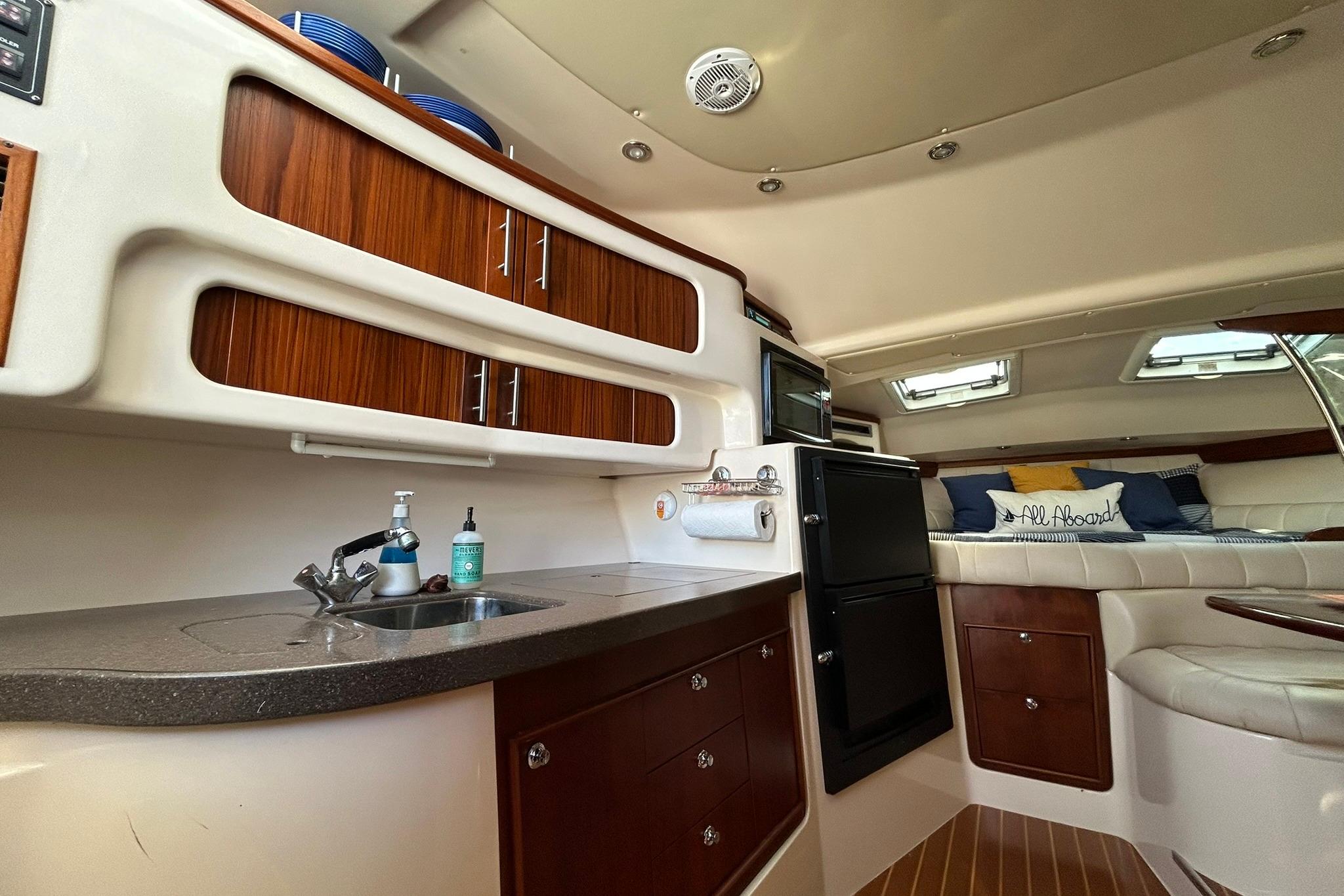 2007 Grady-White Express 360 interior with kitchenette, seating, and storage cabinets.