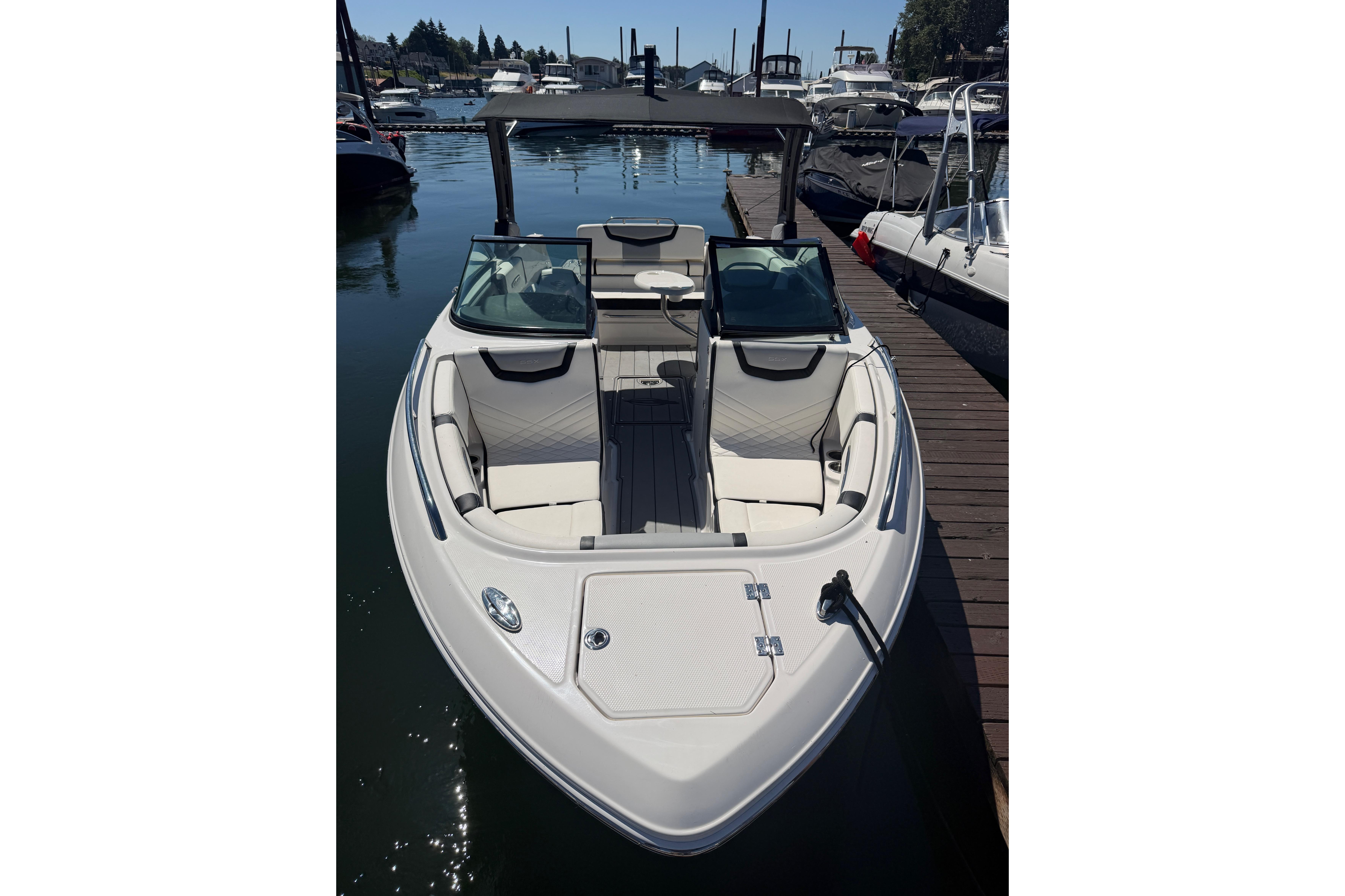 2023 Chaparral 247 SSX boat docked, showcasing sleek design and spacious seating.