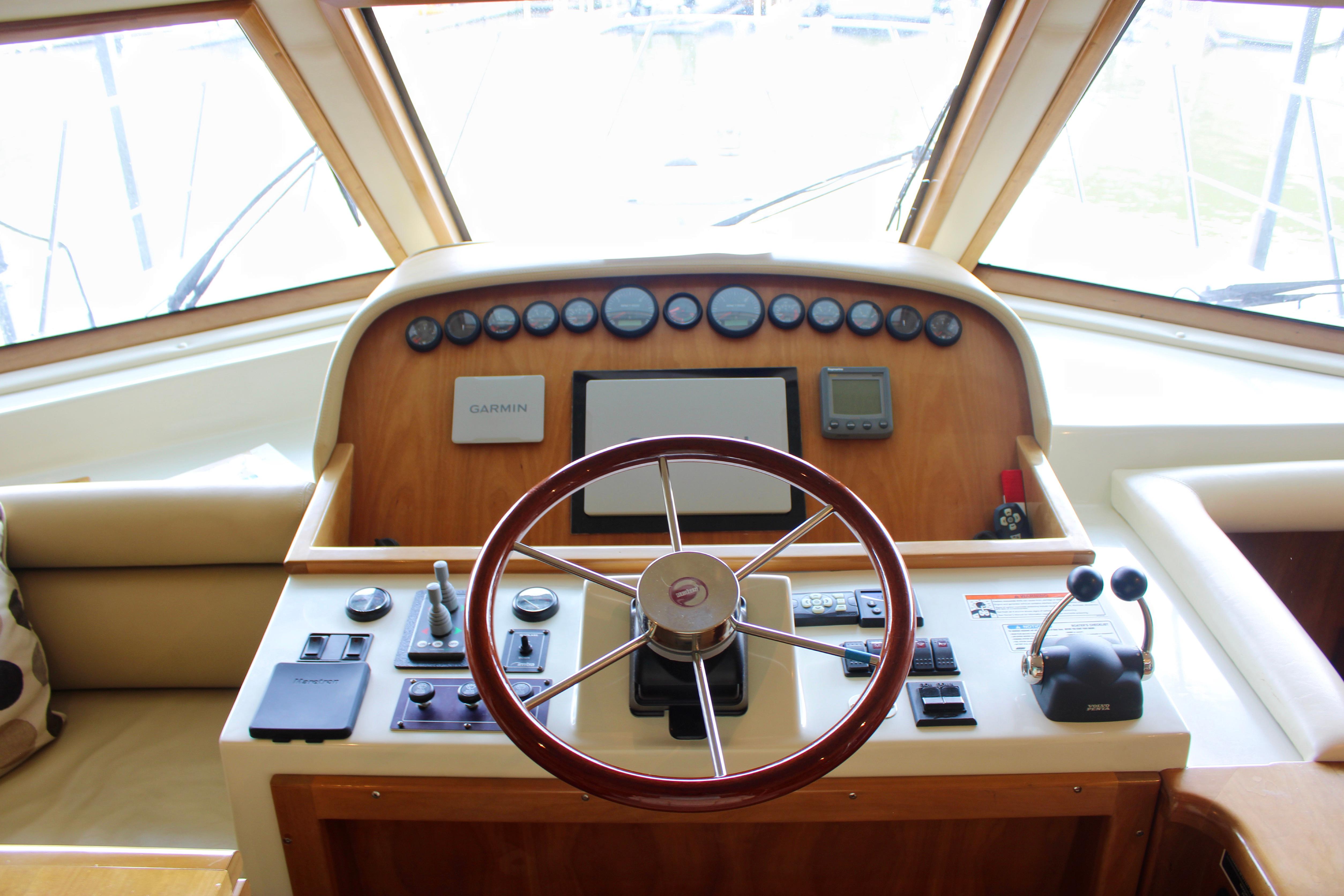 Helm of 2007 Navigator 5100 yacht with steering wheel and navigation controls.