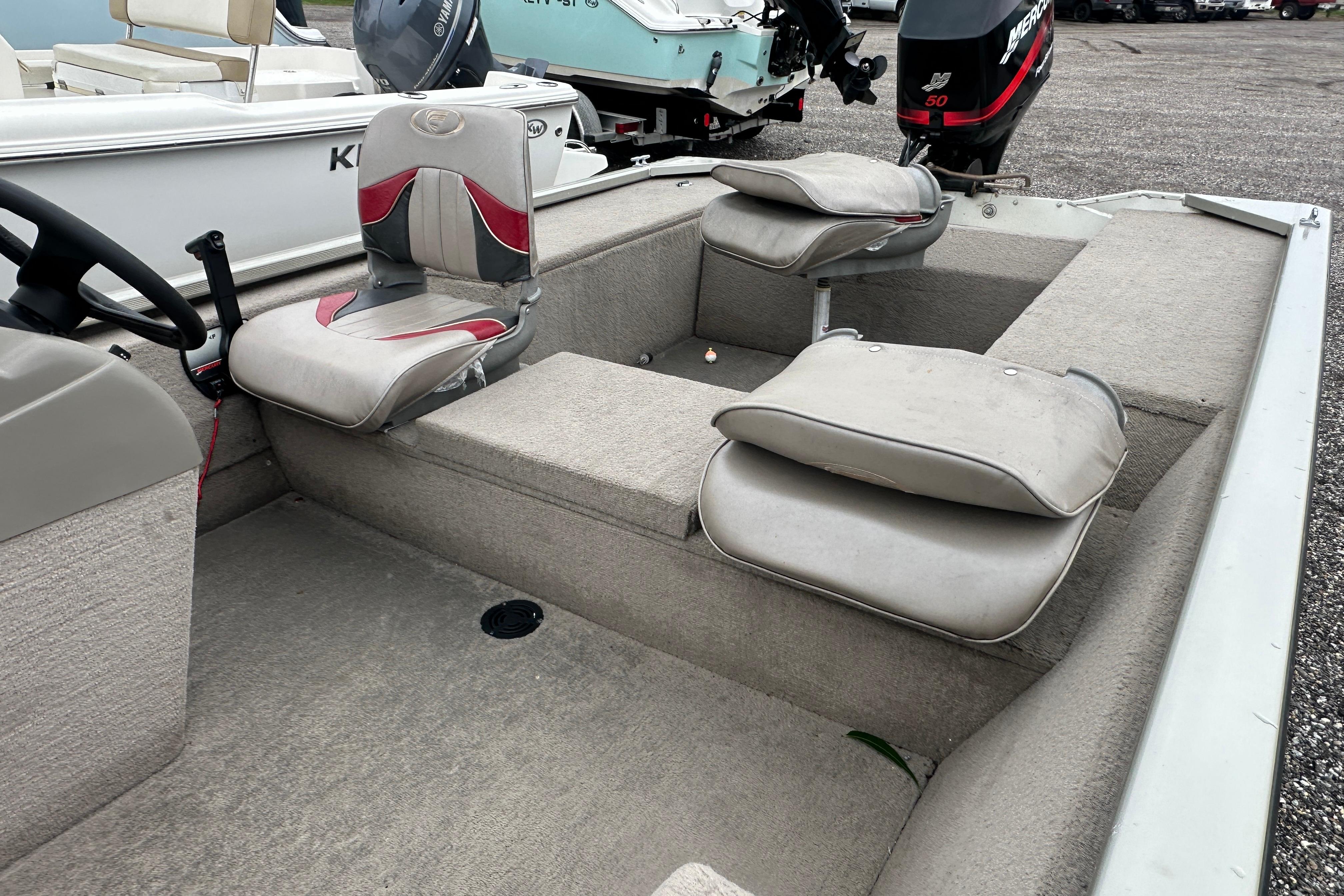 2002 Fisher 1710 boat interior with seating and steering wheel, featuring a Mercury outboard motor.