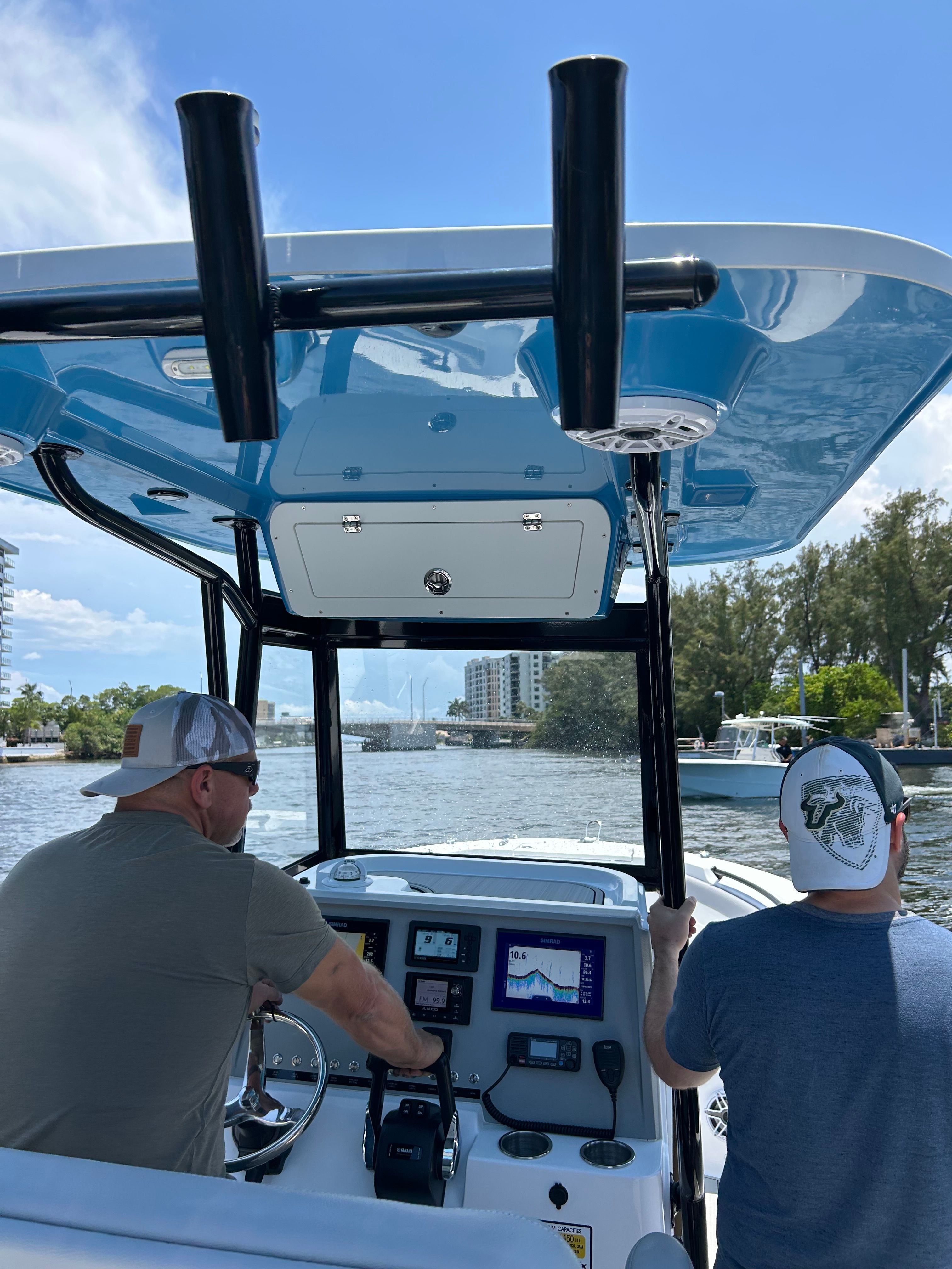 Two men navigating a boat on a river.