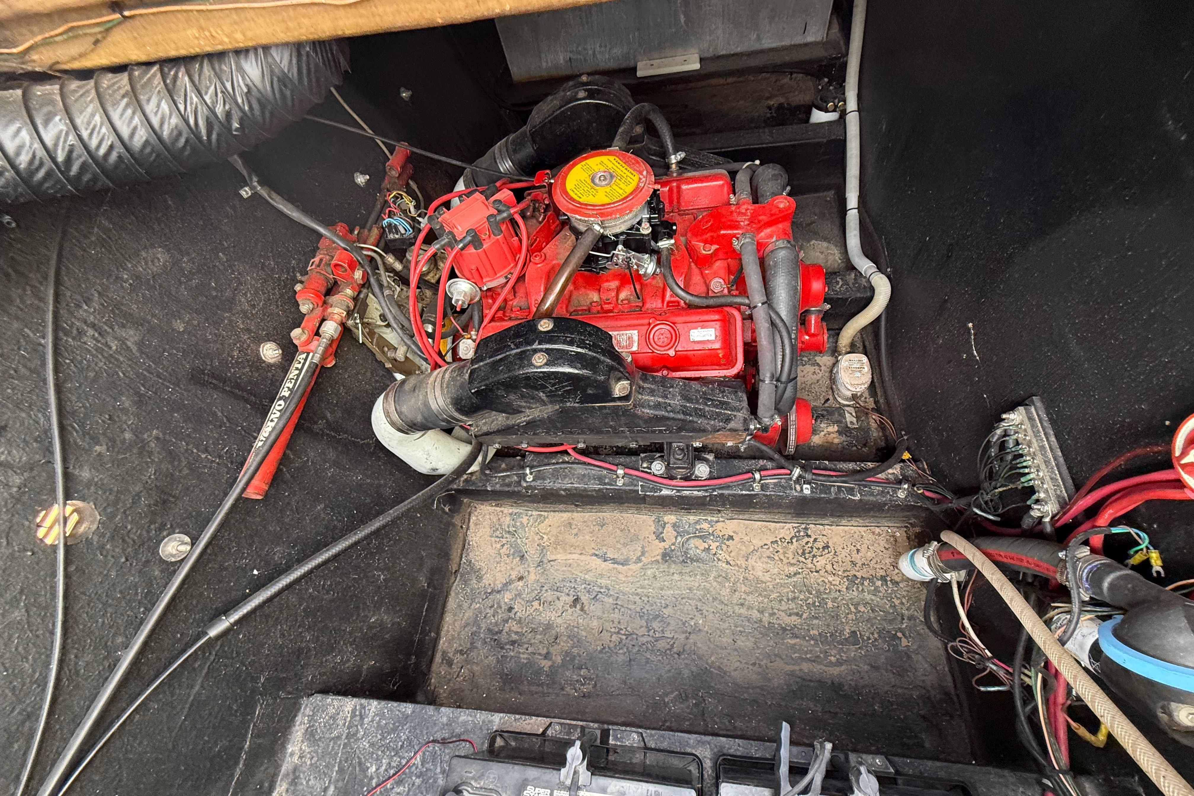 Engine compartment of a 1983 Holiday Mansion 37 Barracuda with red motor components.